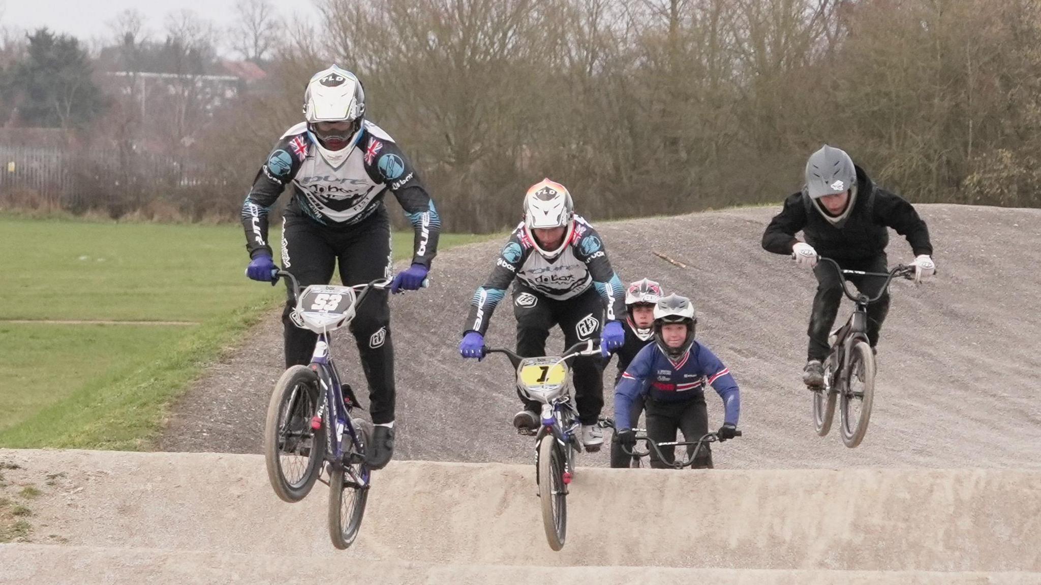 Jared Hill leads four other riders over a jump on the Sloughbottom Park BMX track.