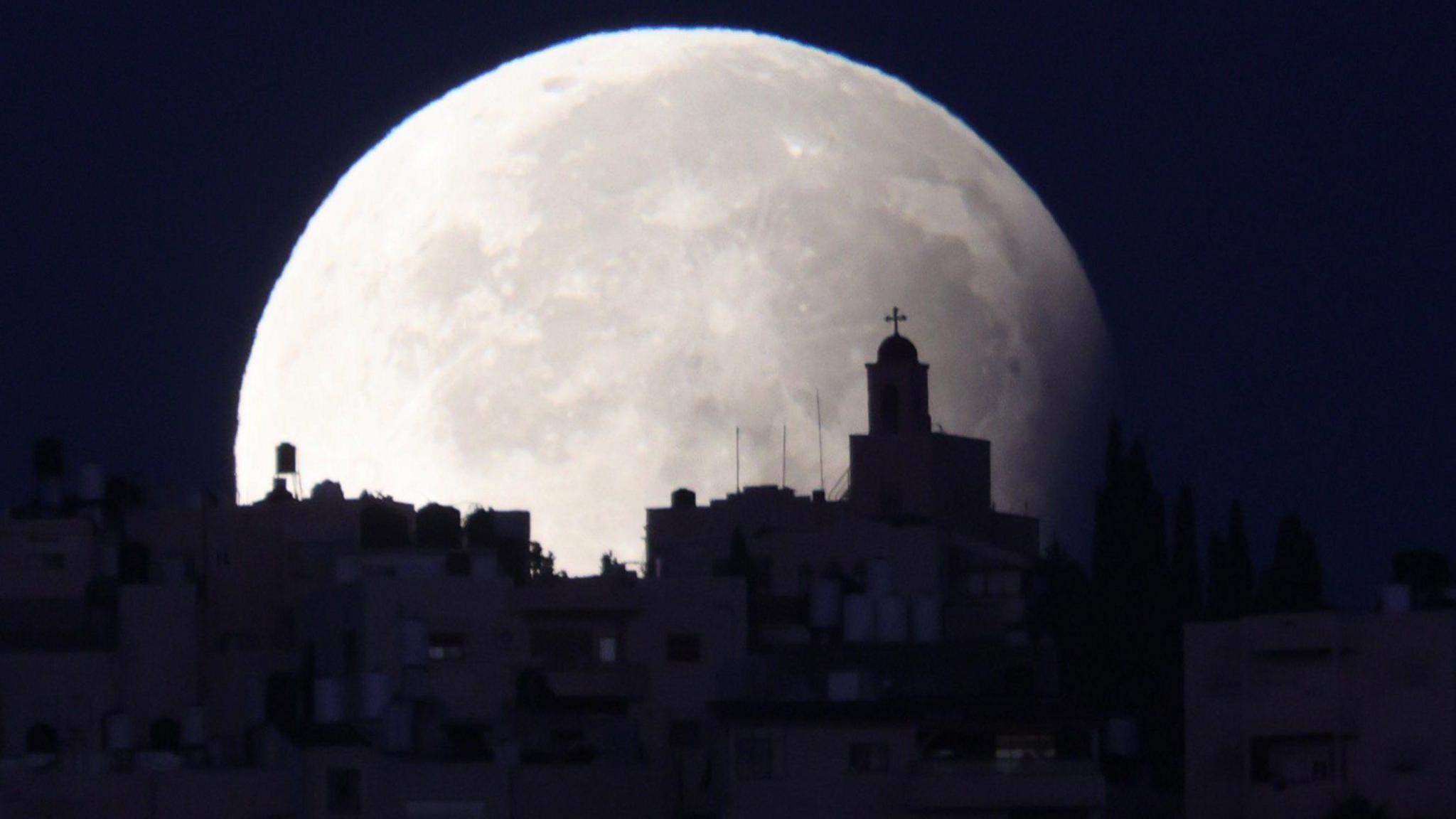 city of Jerusalem in front of supermoon lunar eclipse