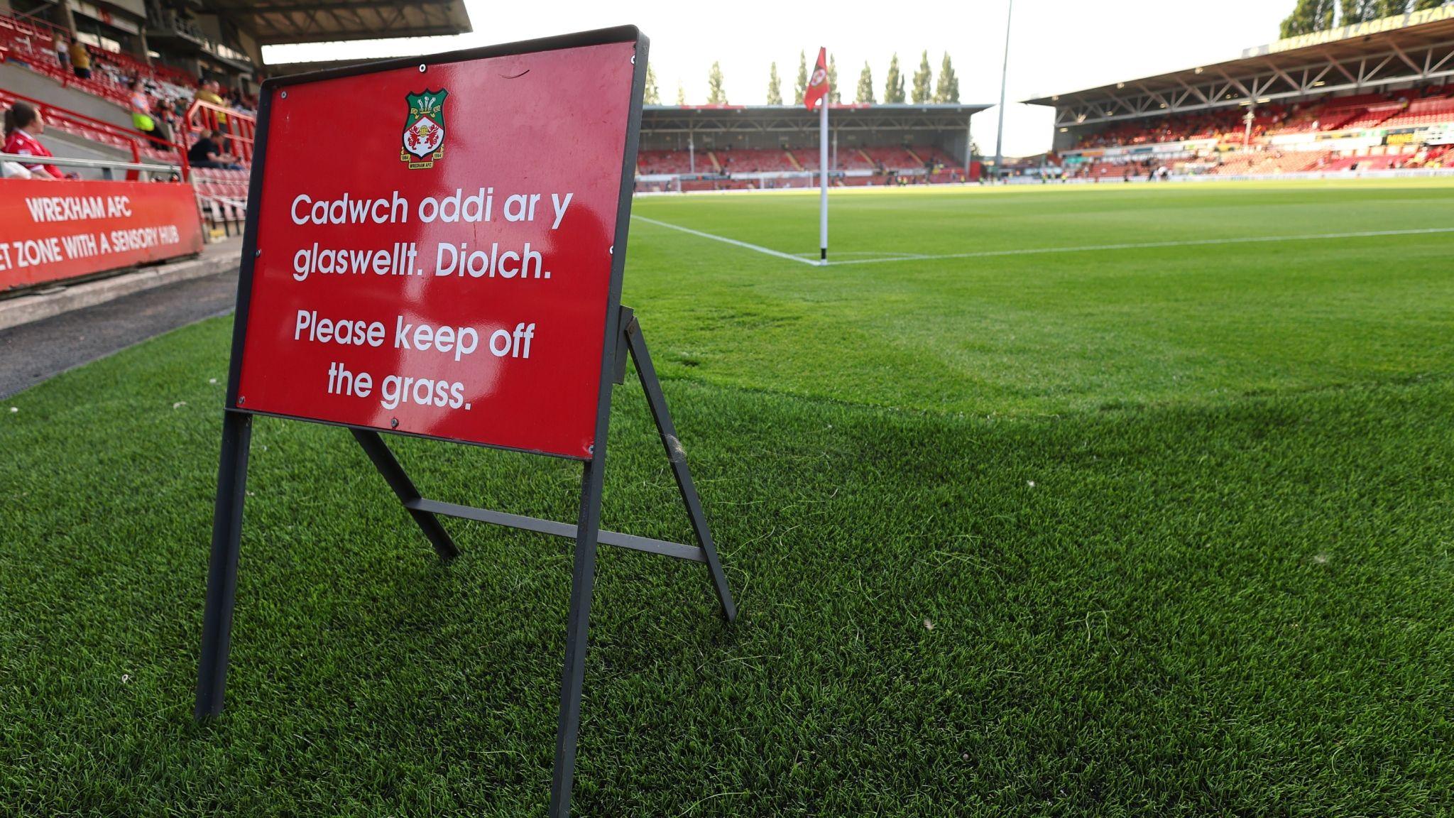 A "please keep off the grass sign" in front of a newly laid pitch at the Stok Car Ras