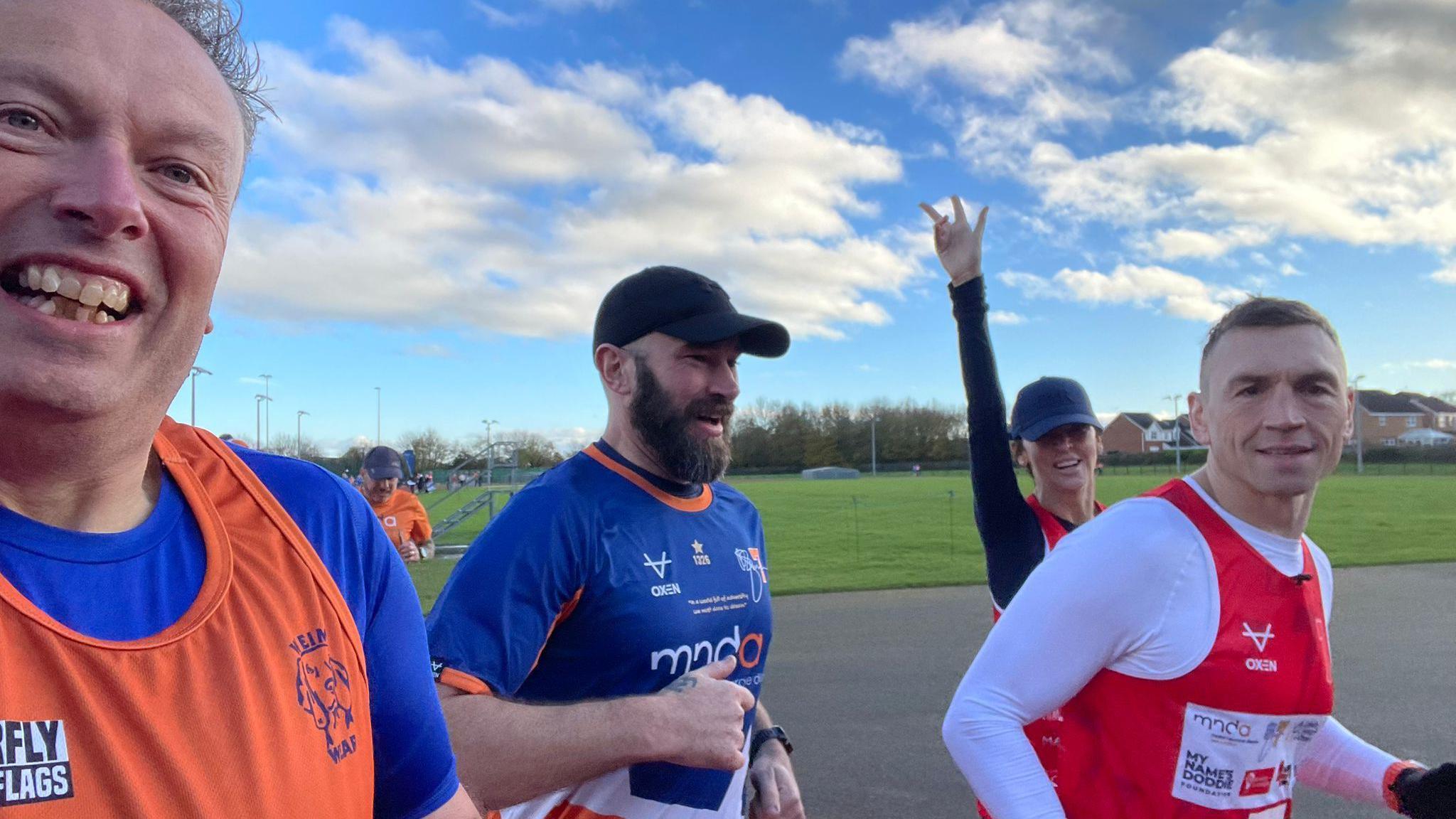 Graham Berry taking part in Kevin Sinfield's 7 in 7 in 7 challenge. Berry is wearing blue and orange, the colours of the MND charity and Sinfield is wearing red and white.