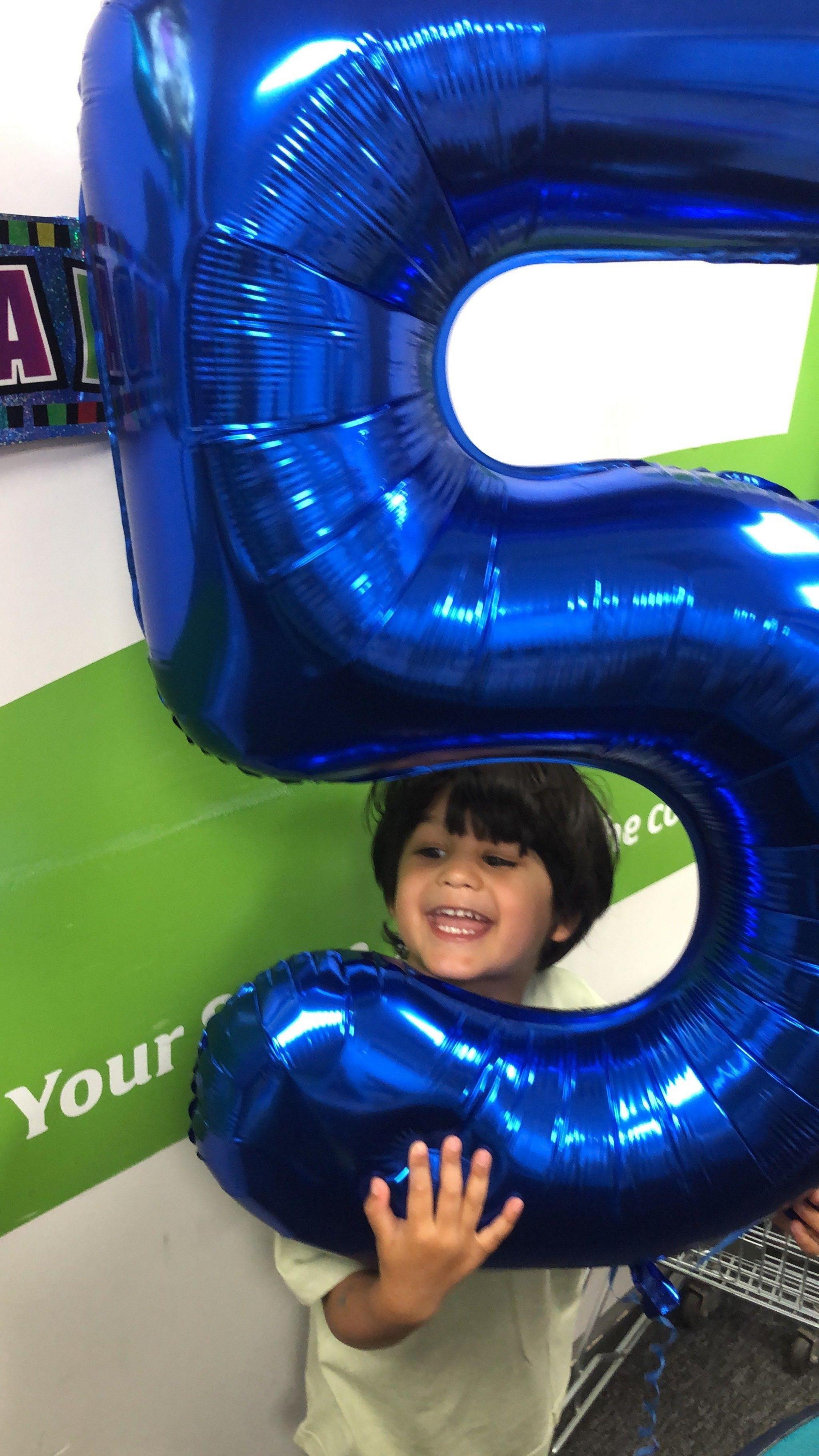 Hari with a birthday balloon of the number five