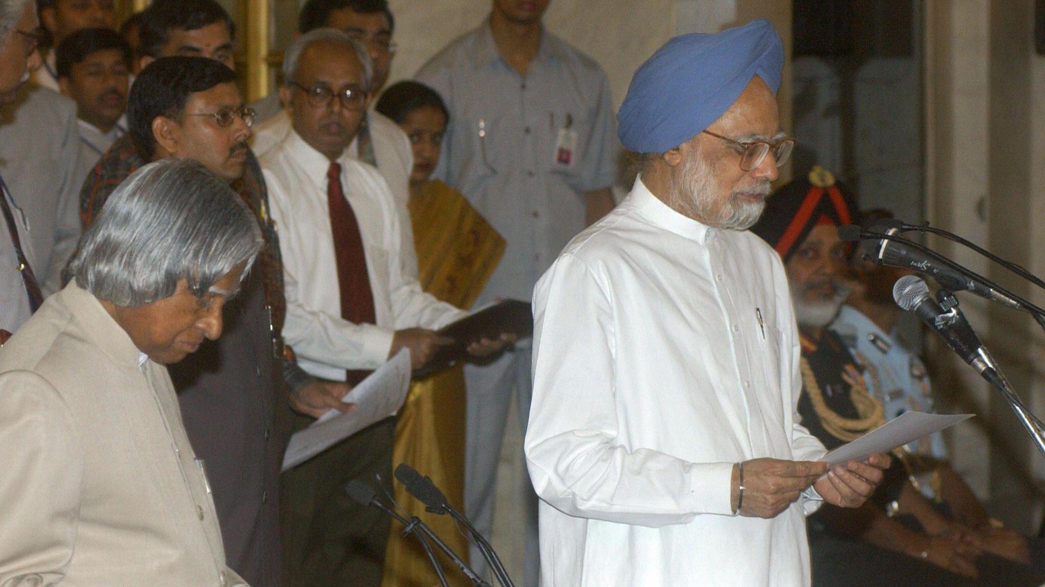 India's new Prime Minister Manmohan Singh (R) reads his oath of office as he stands next to President Abdul Kalam (L) in Delhi on 22 May 2004.