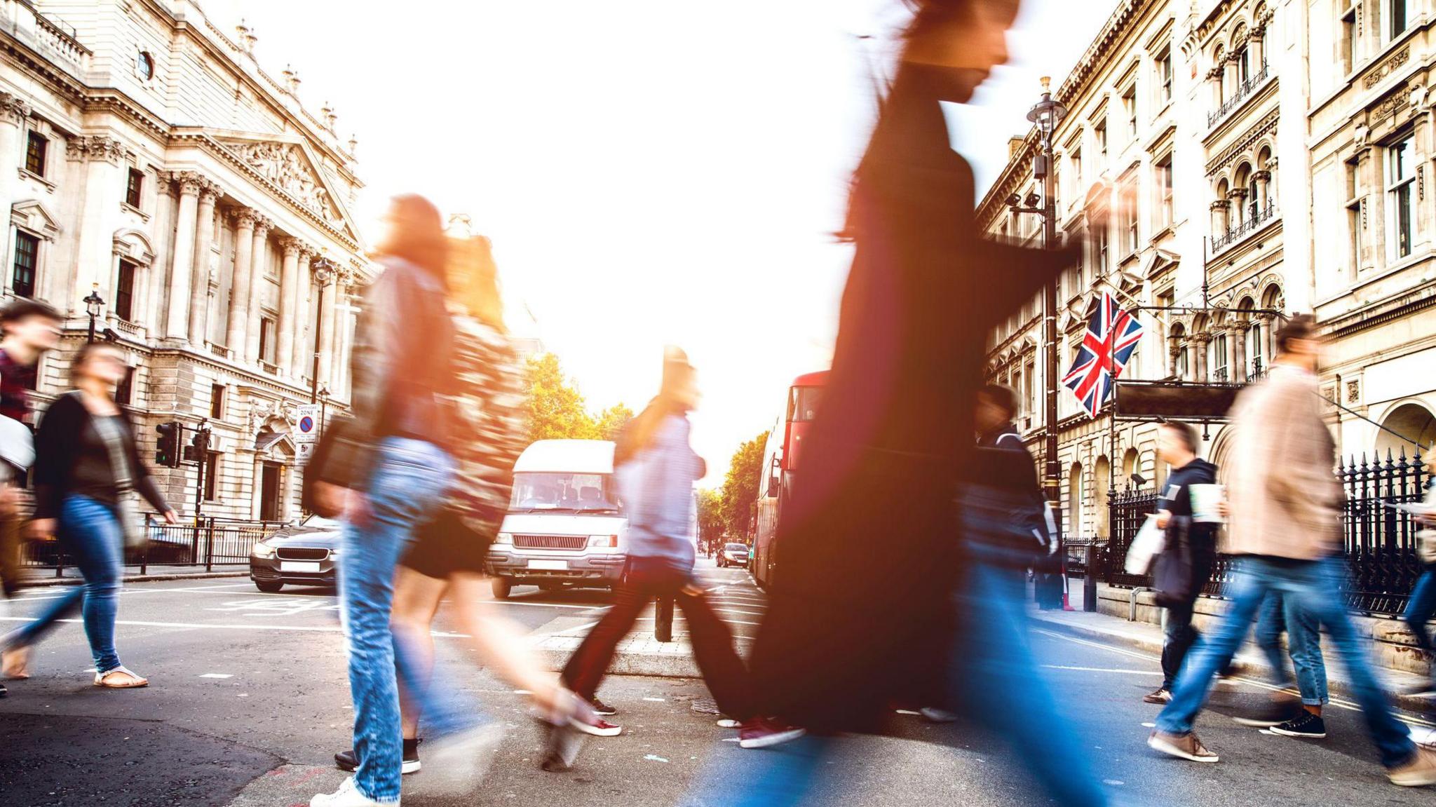 People walking quickly across a road