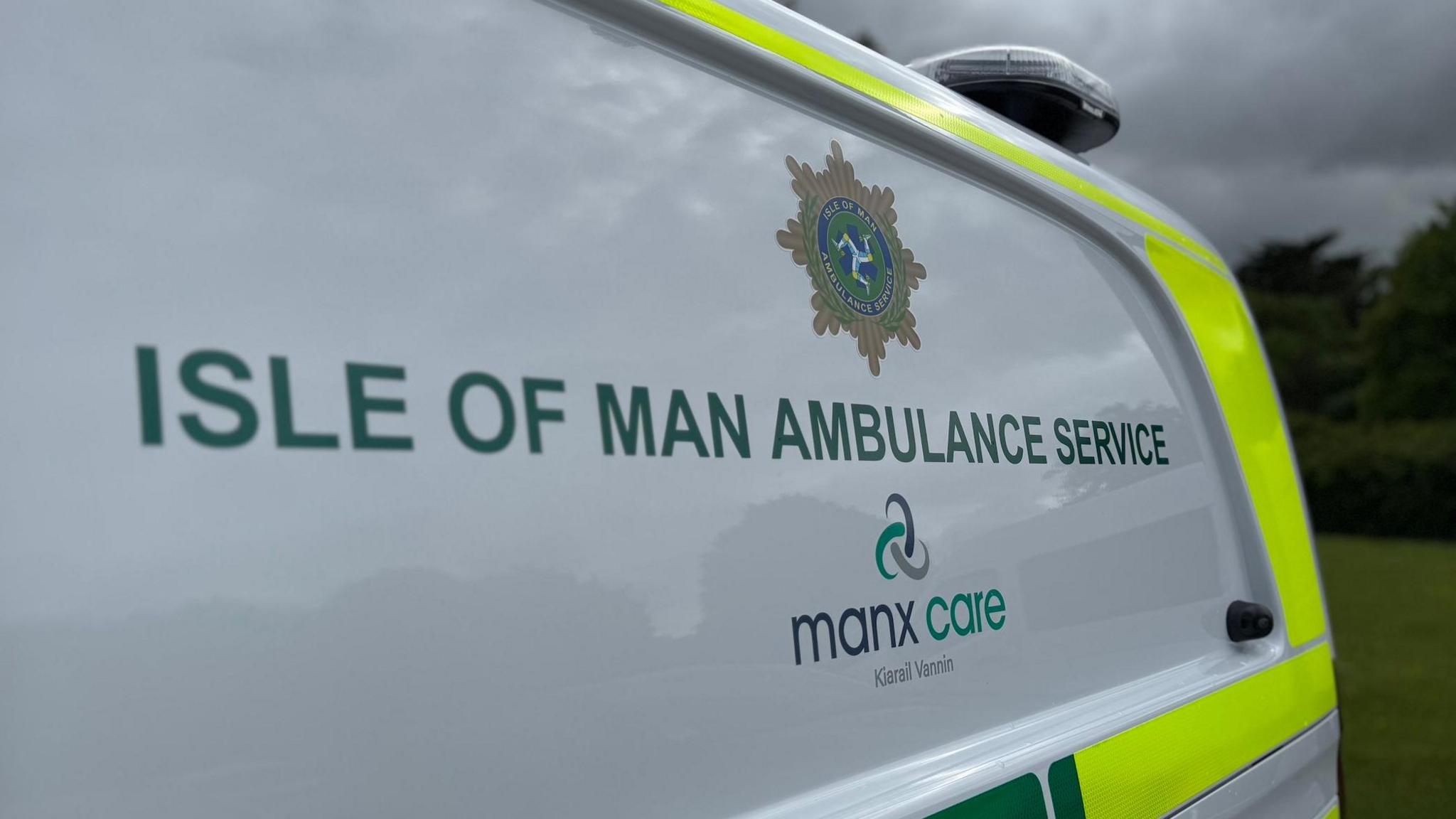 Isle of Man Ambulance Service in green block letters on the side of a Manx Care ambulance. 