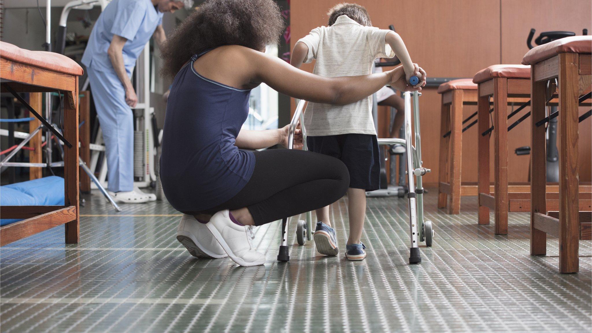 Woman helping disabled child