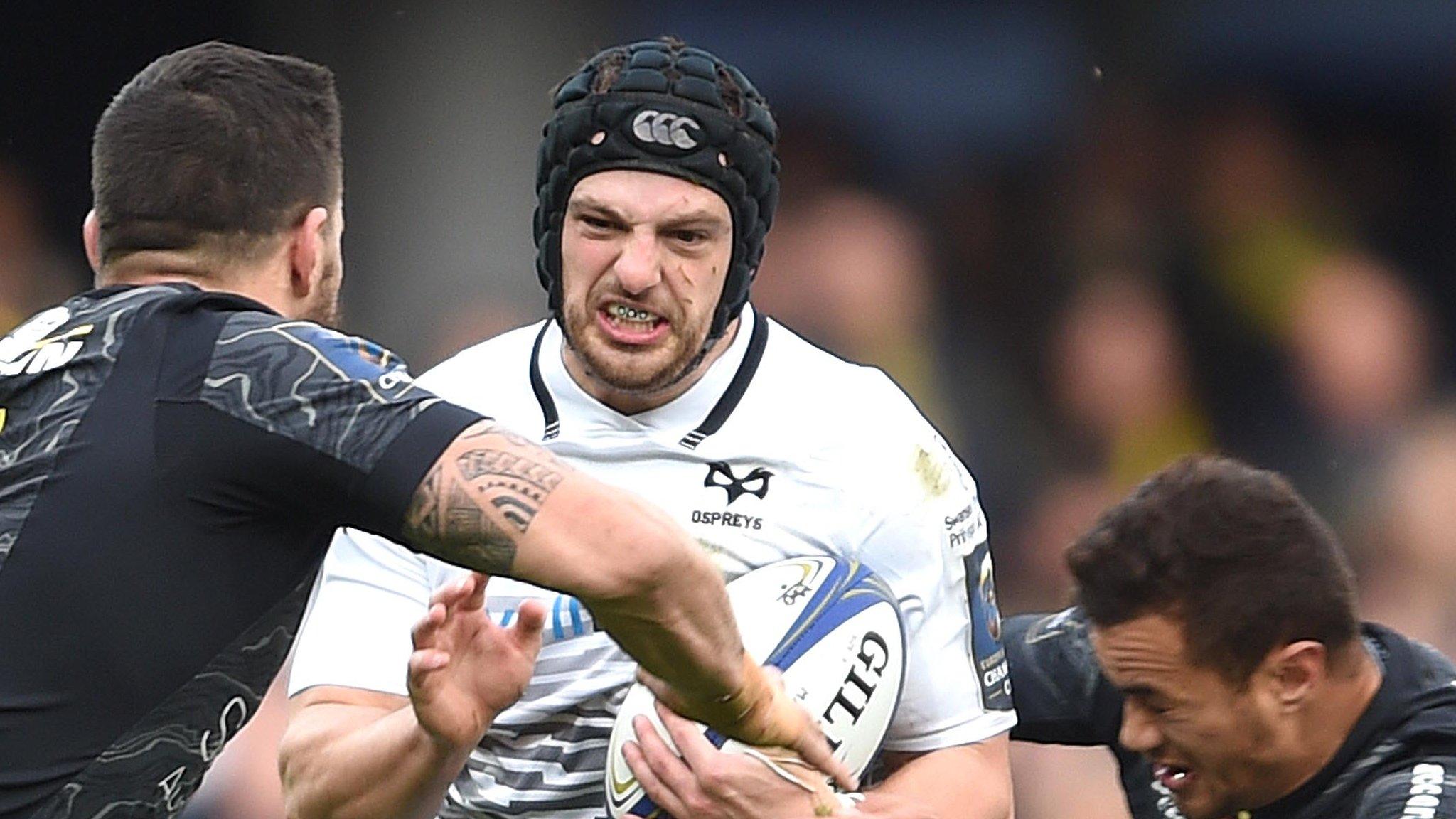 Dan Evans of Ospreys is tackled by Clermont's Remi Grosso and Fritz Lee