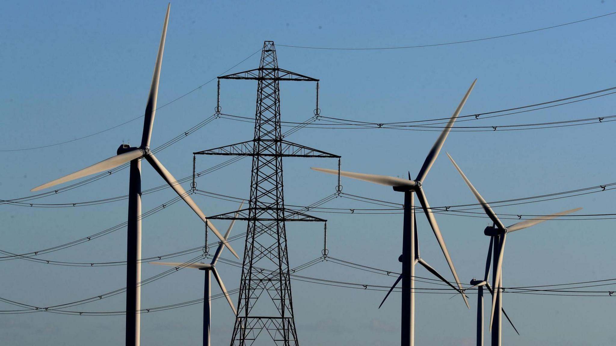 Wind farm turbines and electricity pylons on the Romney Marsh in Kent.