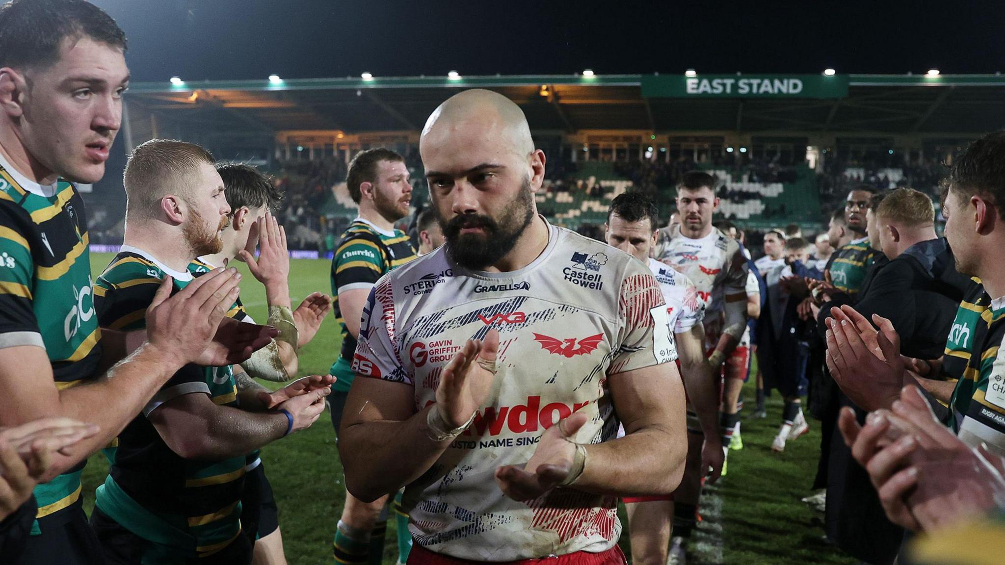 Scarlets captain Josh Macleod is applauded off the field by Northampton Saints players