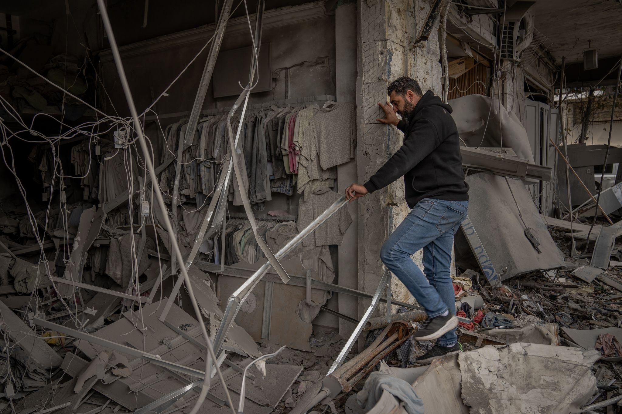 Yusuf Mouzzain climbs into his shop. "This is the worst war we have seen," he said.