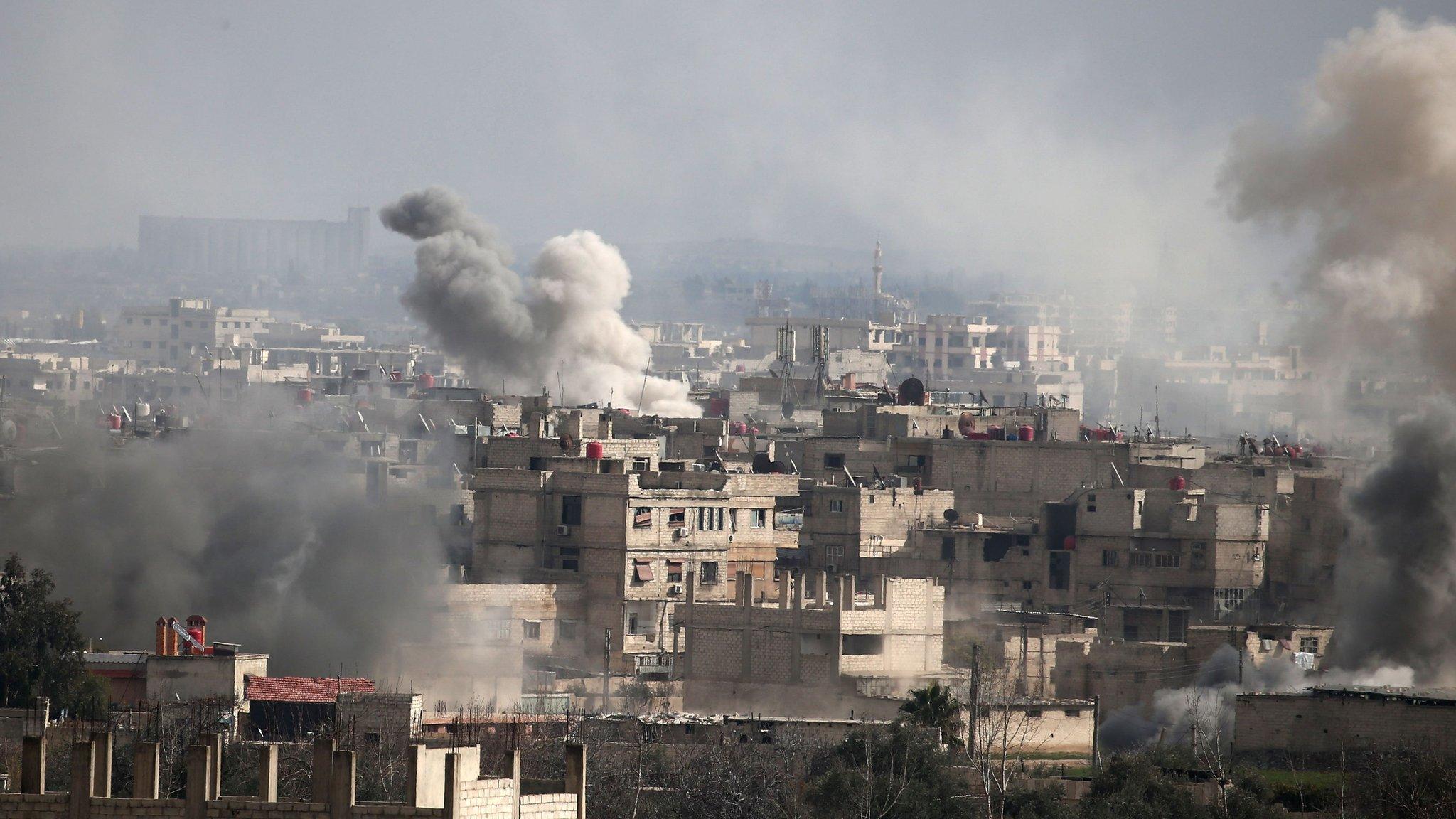 A picture taken on February 20, 2018 shows smoke plumes rising following a reported regime air strike in the rebel-held town of Hamouria, in the besieged Eastern Ghouta region on the outskirts of the capital Damascus.