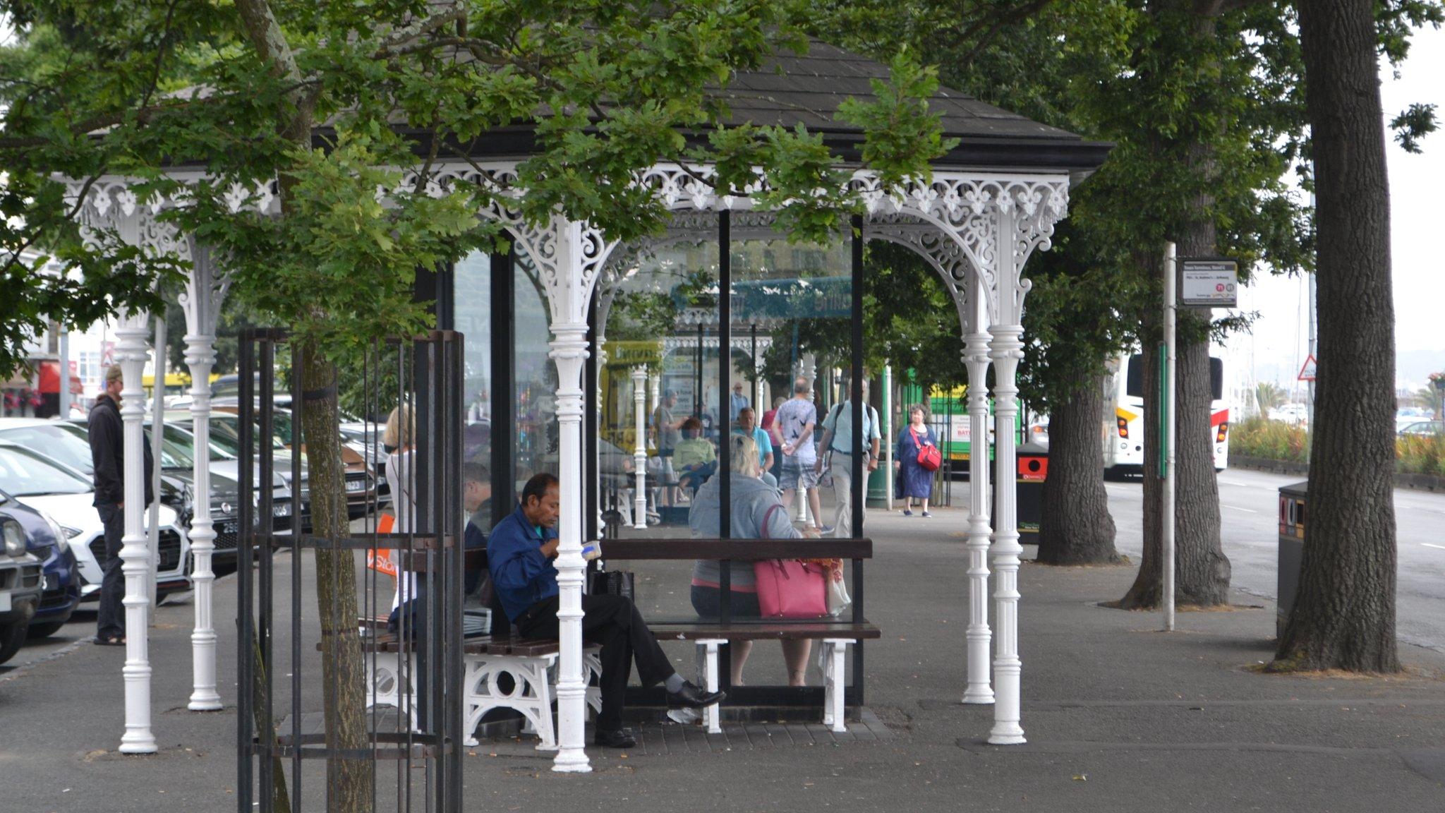 Guernsey's bus terminus in St Peter Port with people sat on benches