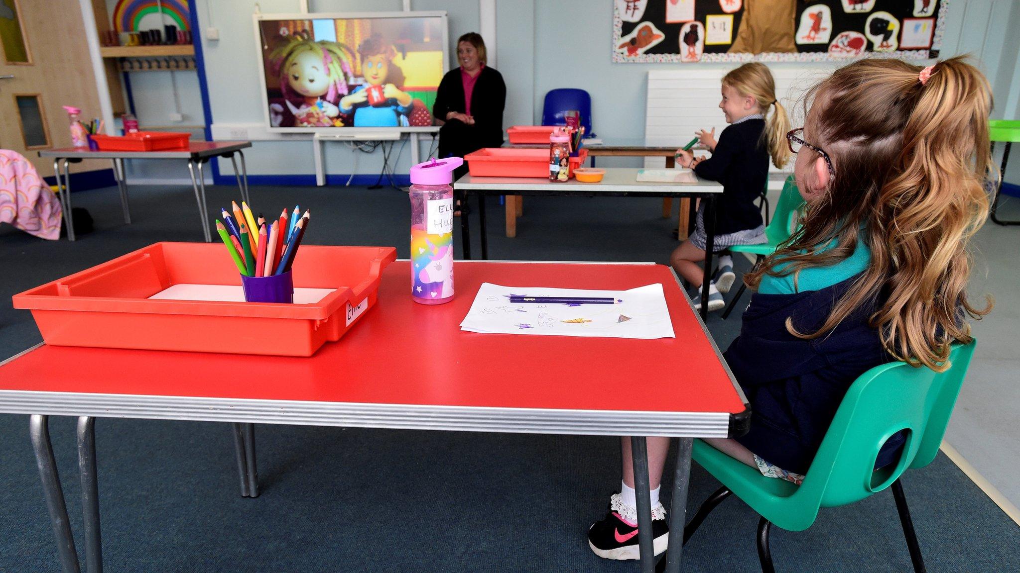 Primary pupils sitting socially distanced in a classroom