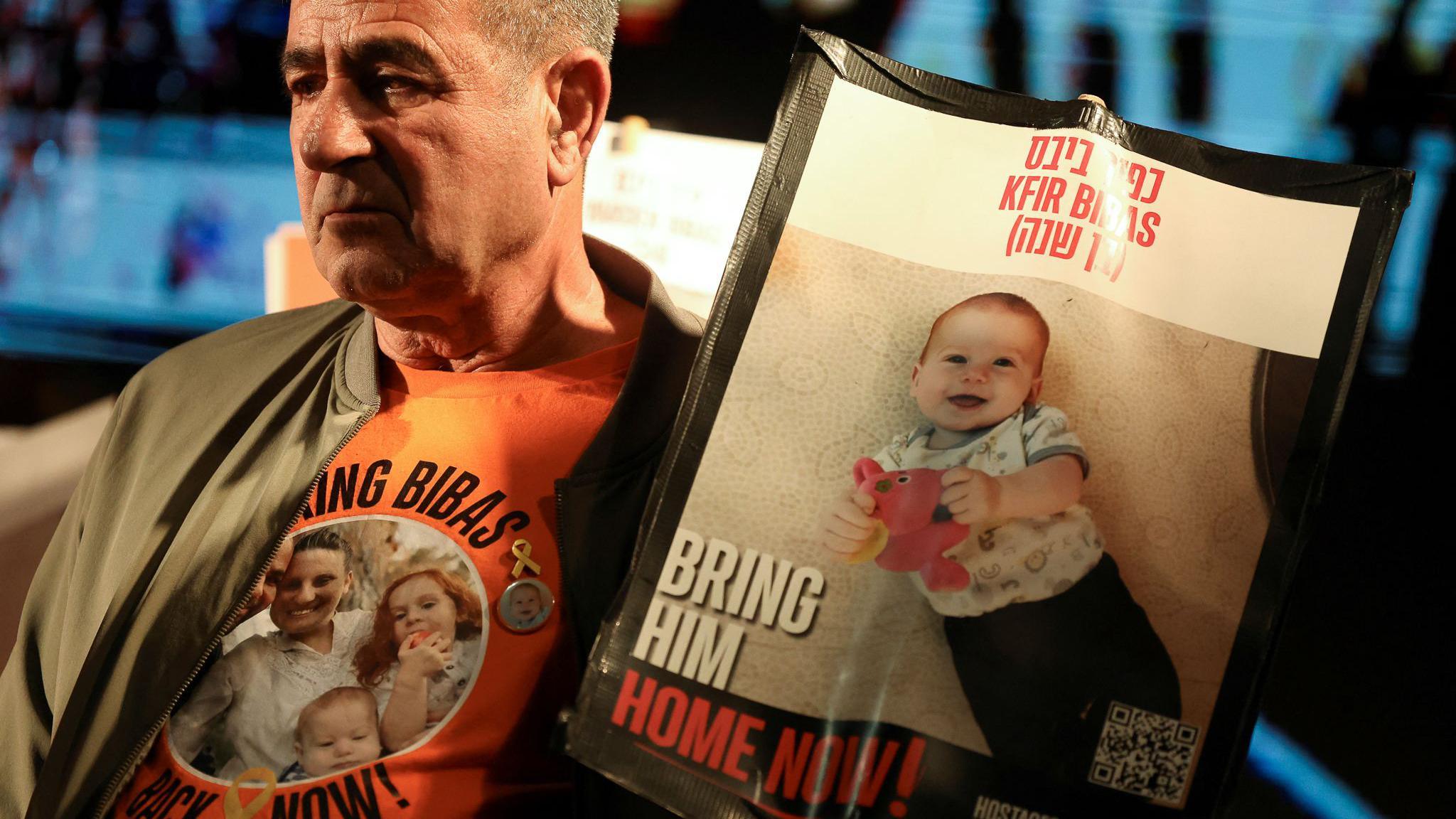 Eli Bibas, grandfather of the youngest hostage in Gaza, Kfir Bibas, holds a poster calling for his release