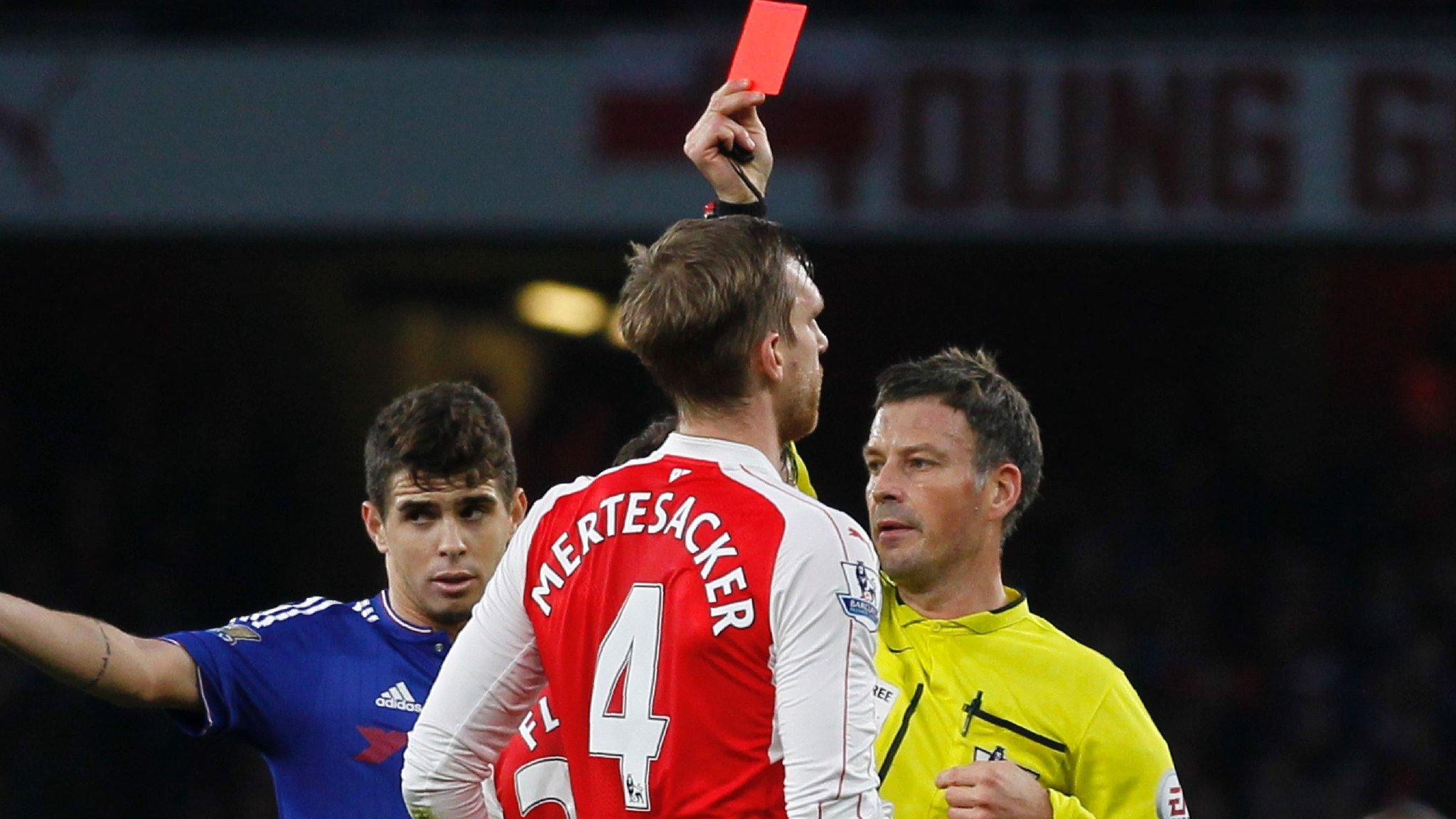 Mark Clattenburg shows Per Mertesacker a red card