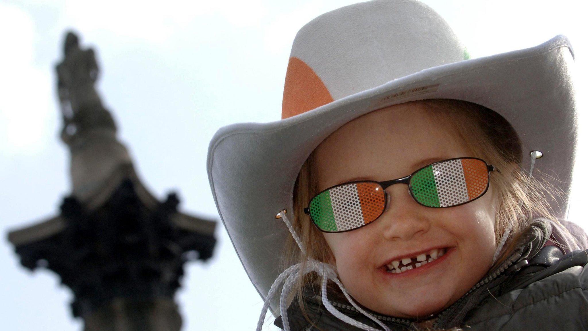 Little girl in novelty Irish sunglasses in front of Nelson's column