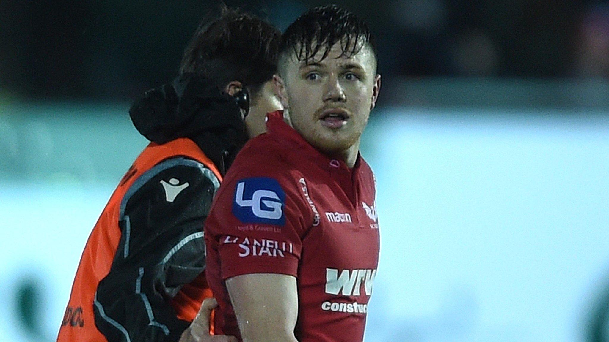 Scarlets Steff Evans being led from the pitch after his red card against Ospreys