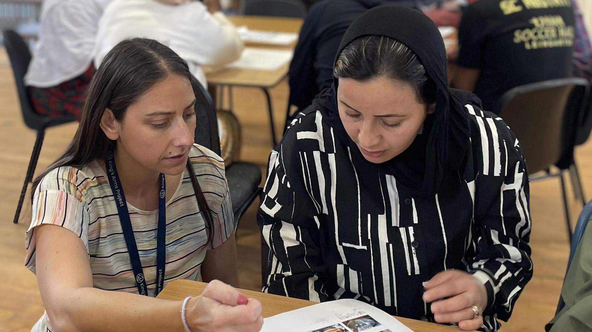 Christy, teaching Zarifa (right) who to learn English