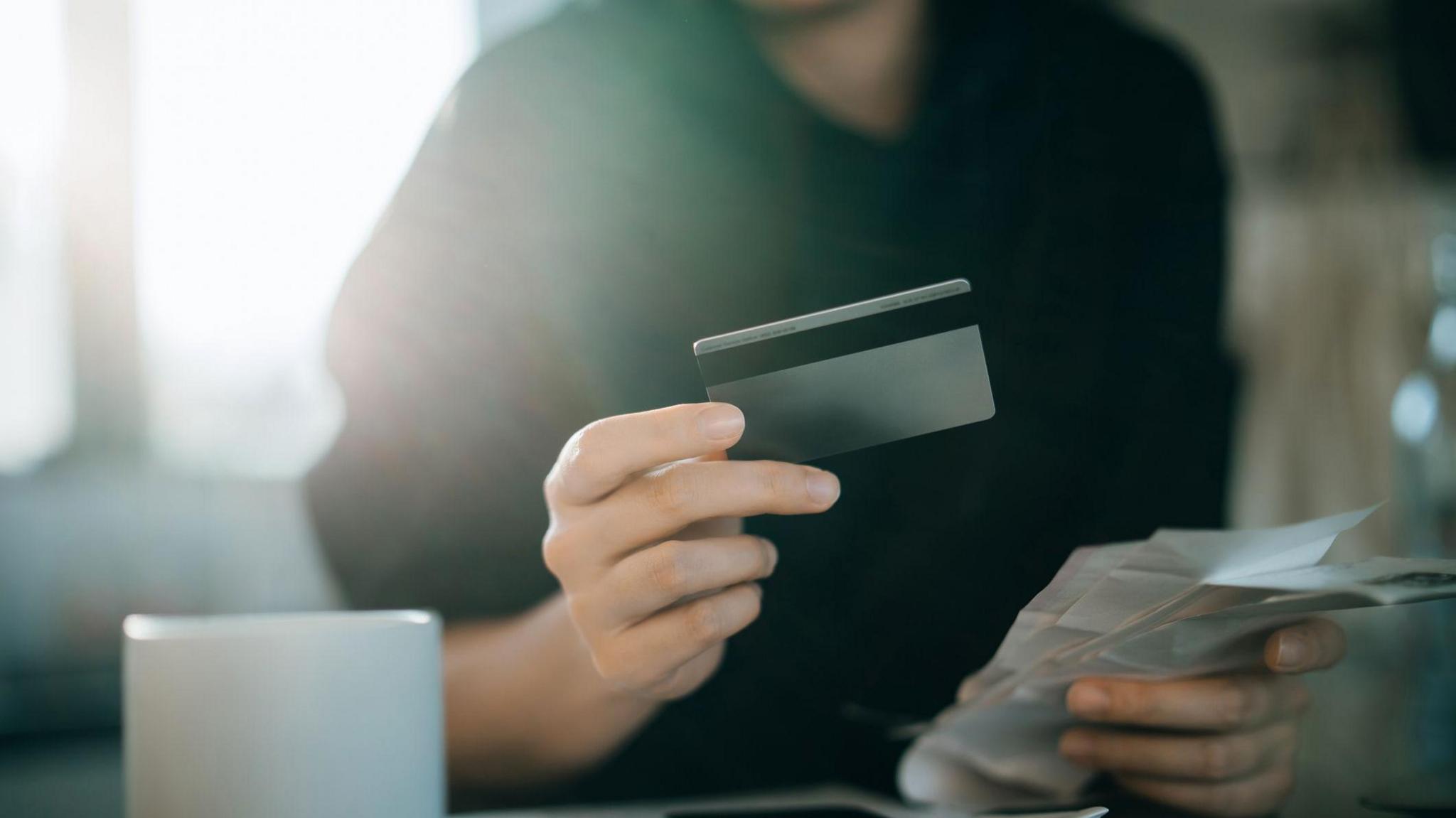 A stock image of a woman holding a credit card