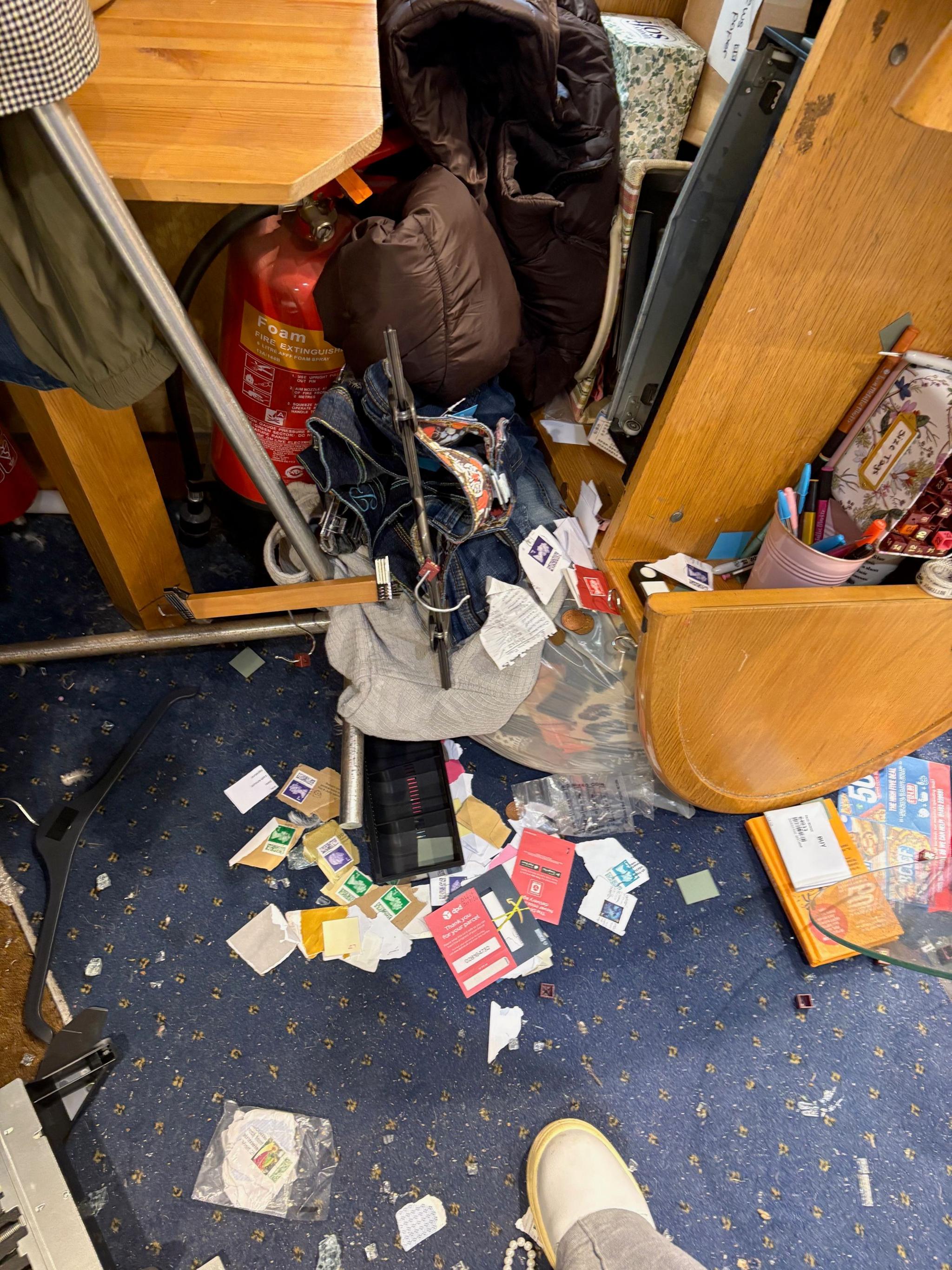 The picture shows the shop having been ransacked with items on the floor and dragged out of a cupboard.