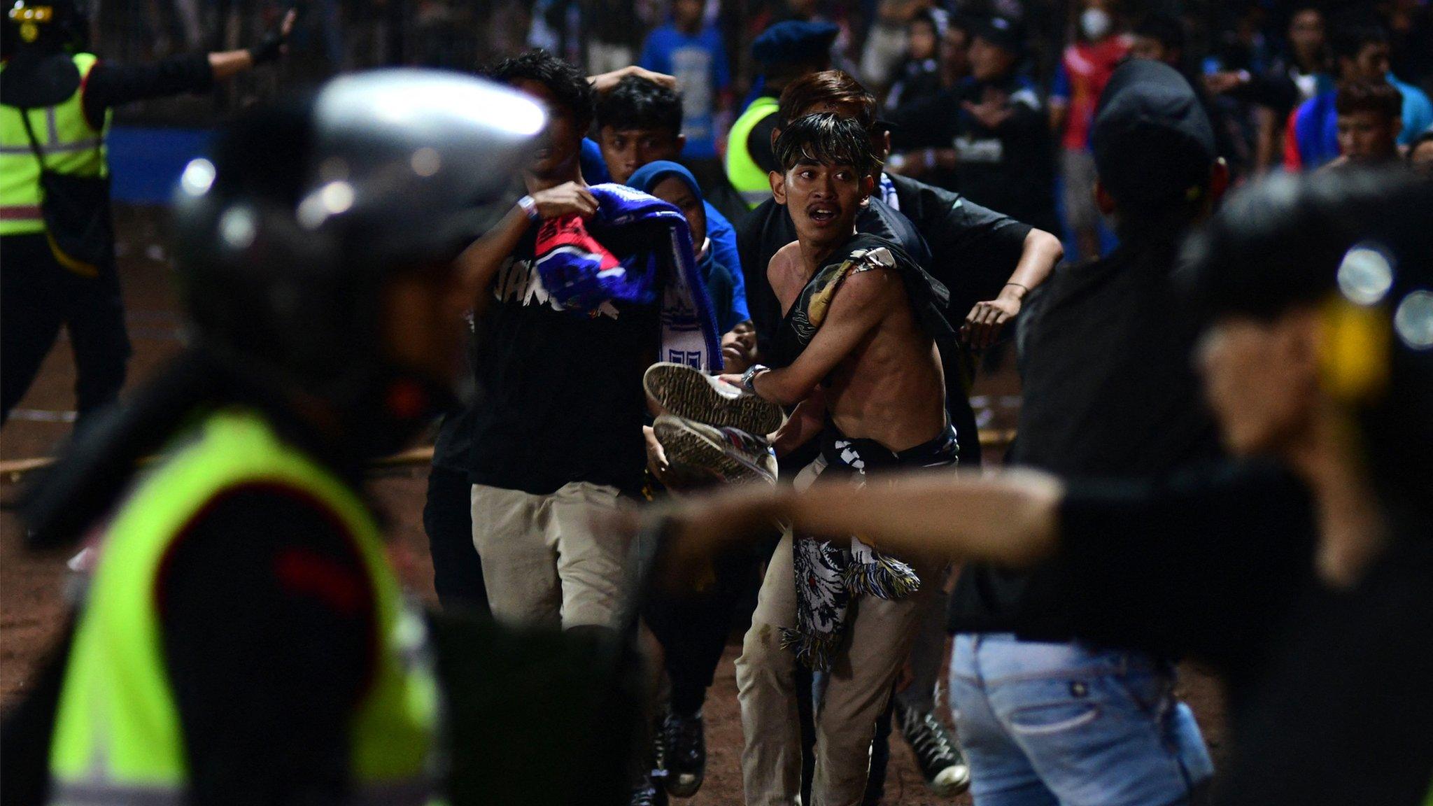 A group of people carry a man in Kanjuruhan stadium