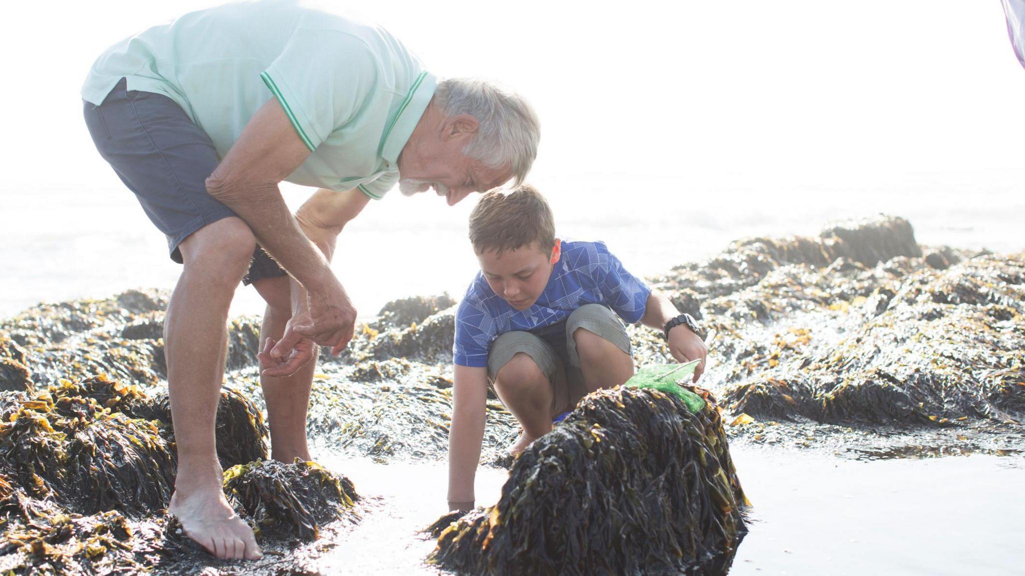 Boy at beach with grandfather.