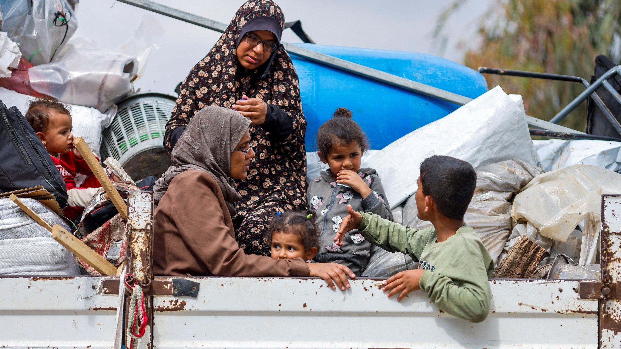 Palestinians ride in the back of a van as they flee Rafah, in the southern Gaza Strip (13 May 2024)