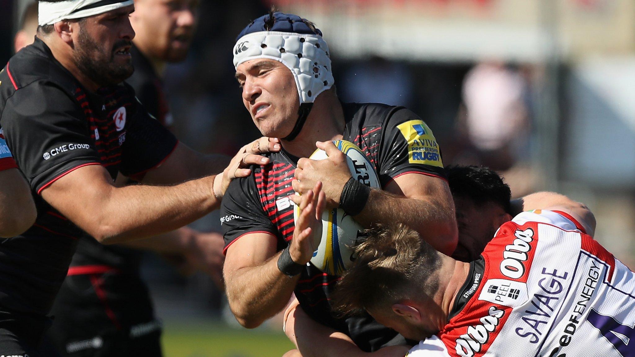 Saracens hooker Schalk Brits is tackled by Gloucester forward Tom Savage