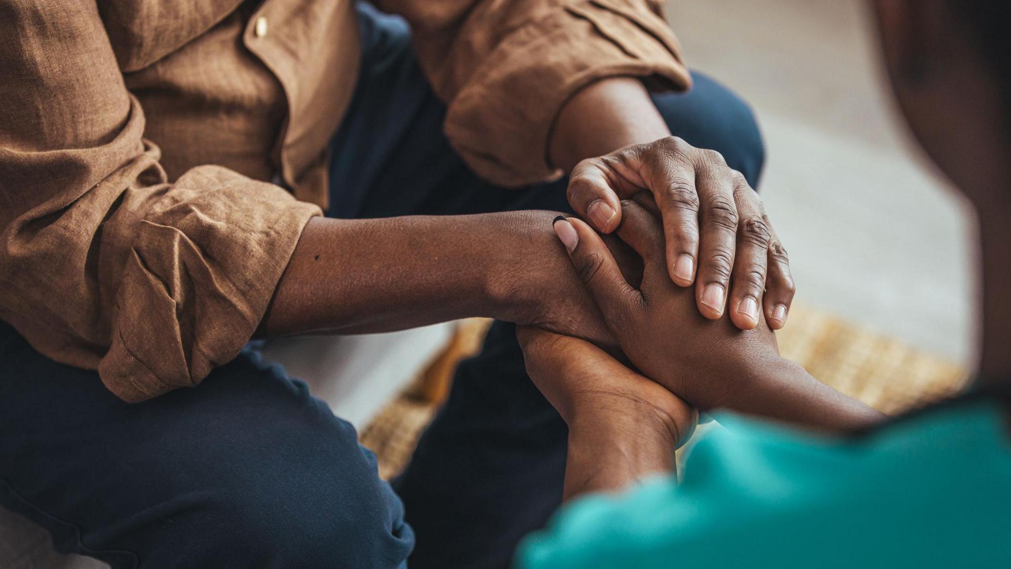 One person holding another person's hands.