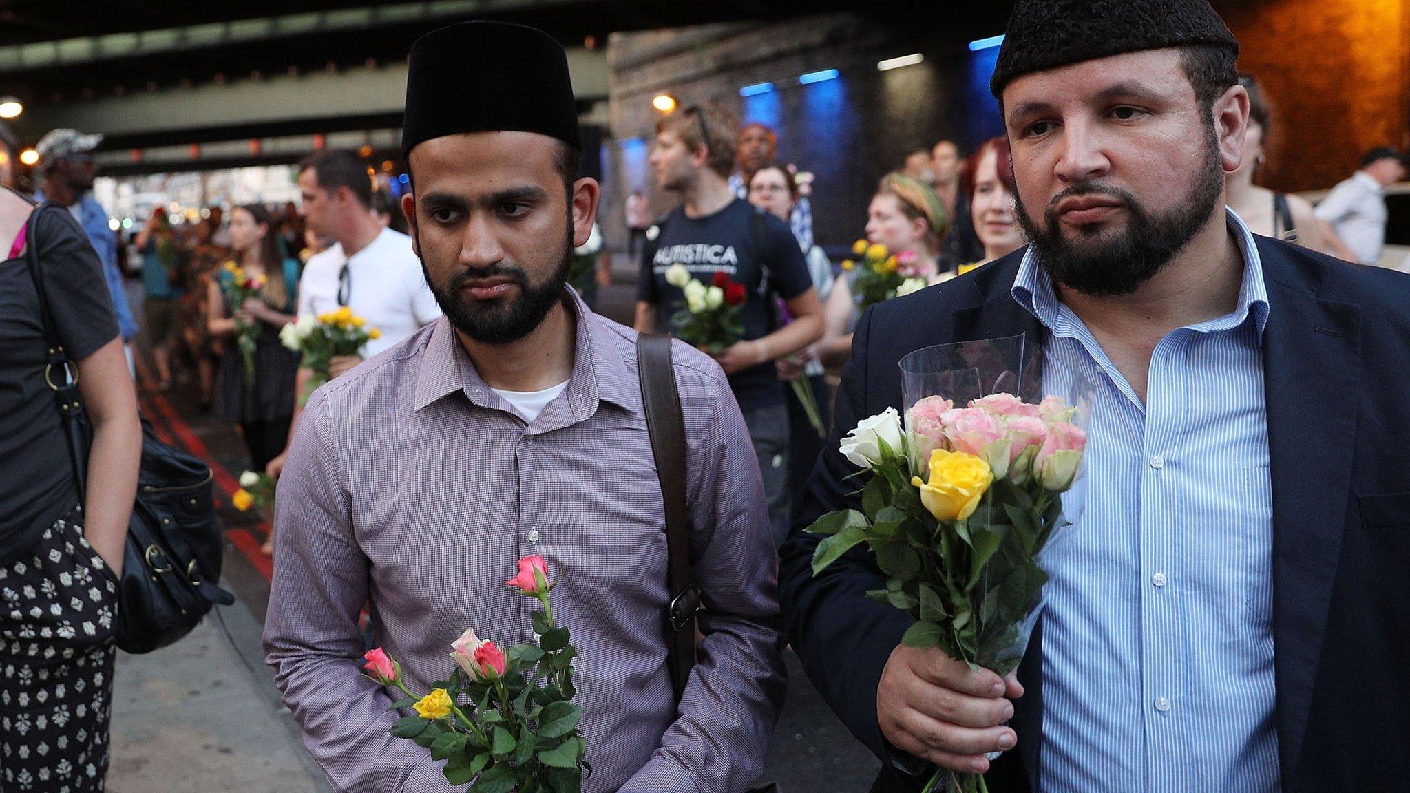 Men bring flowers to the vigil in Finsbury Park