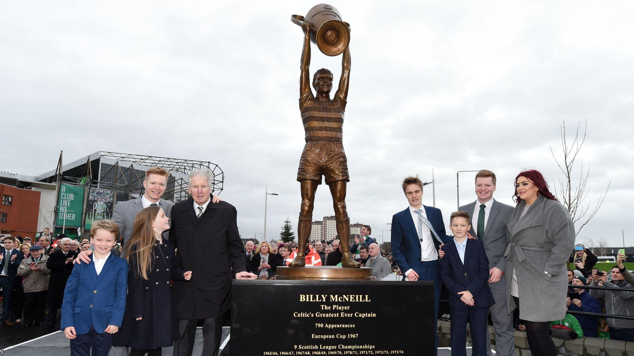 Billy McNeil and his family stand next to his tribute statue