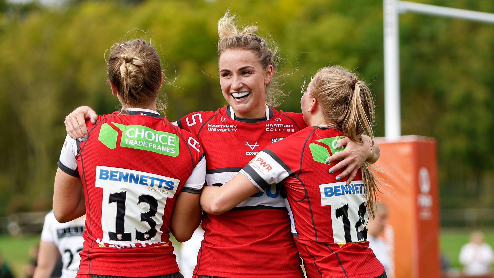 Charlie Woodman hugs two Gloucester-Hartpury teammates