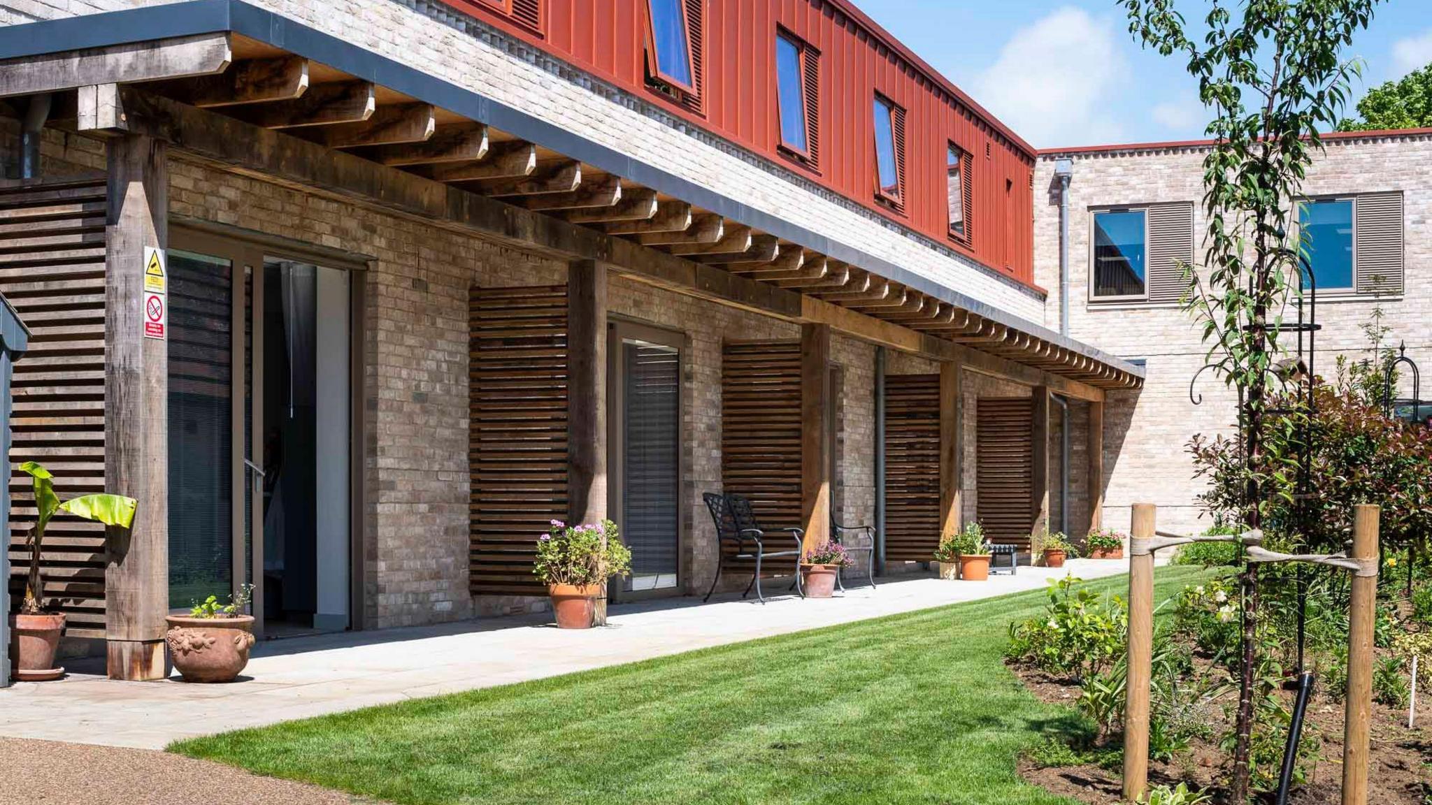 Doors from the hospice leading to a terrace and lawn