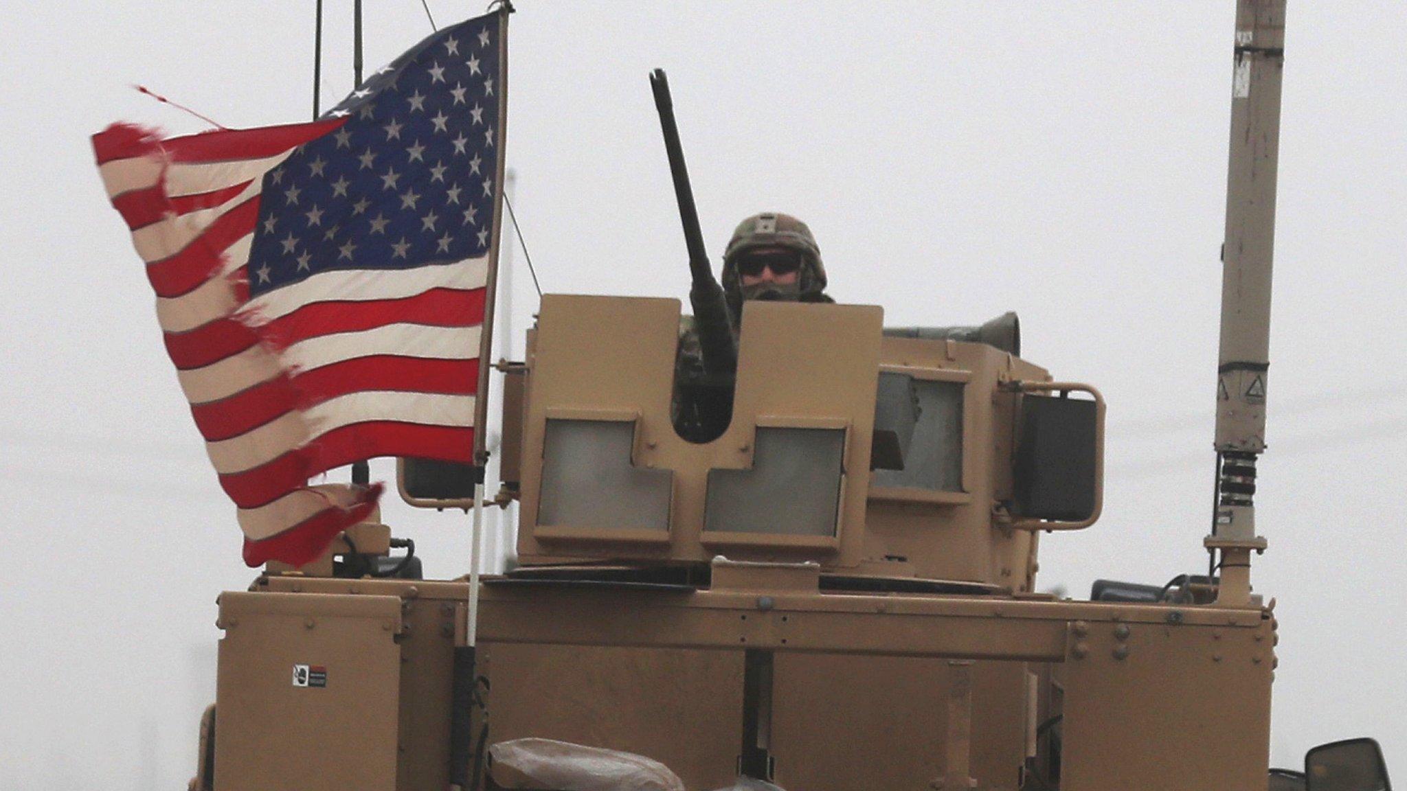 A US soldier riding an armoured personnel carrier in Syria's northern city of Manbij. 30 Dec 2018