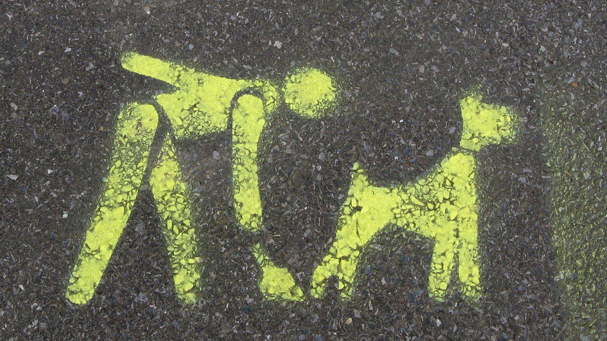 A stencil on the pavement asking you to clean up after your dog