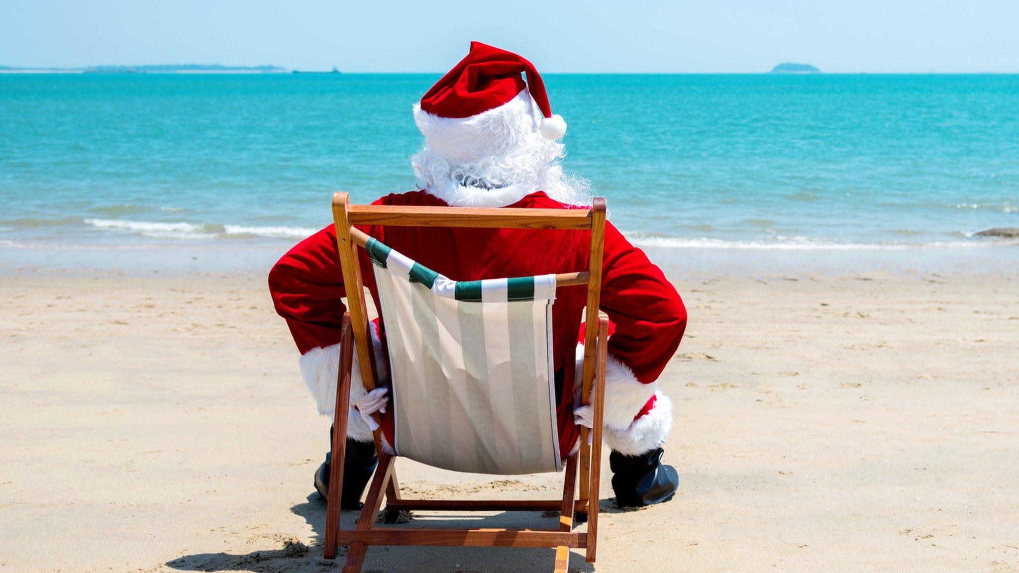 Man dressed as Santa Claus on a beach