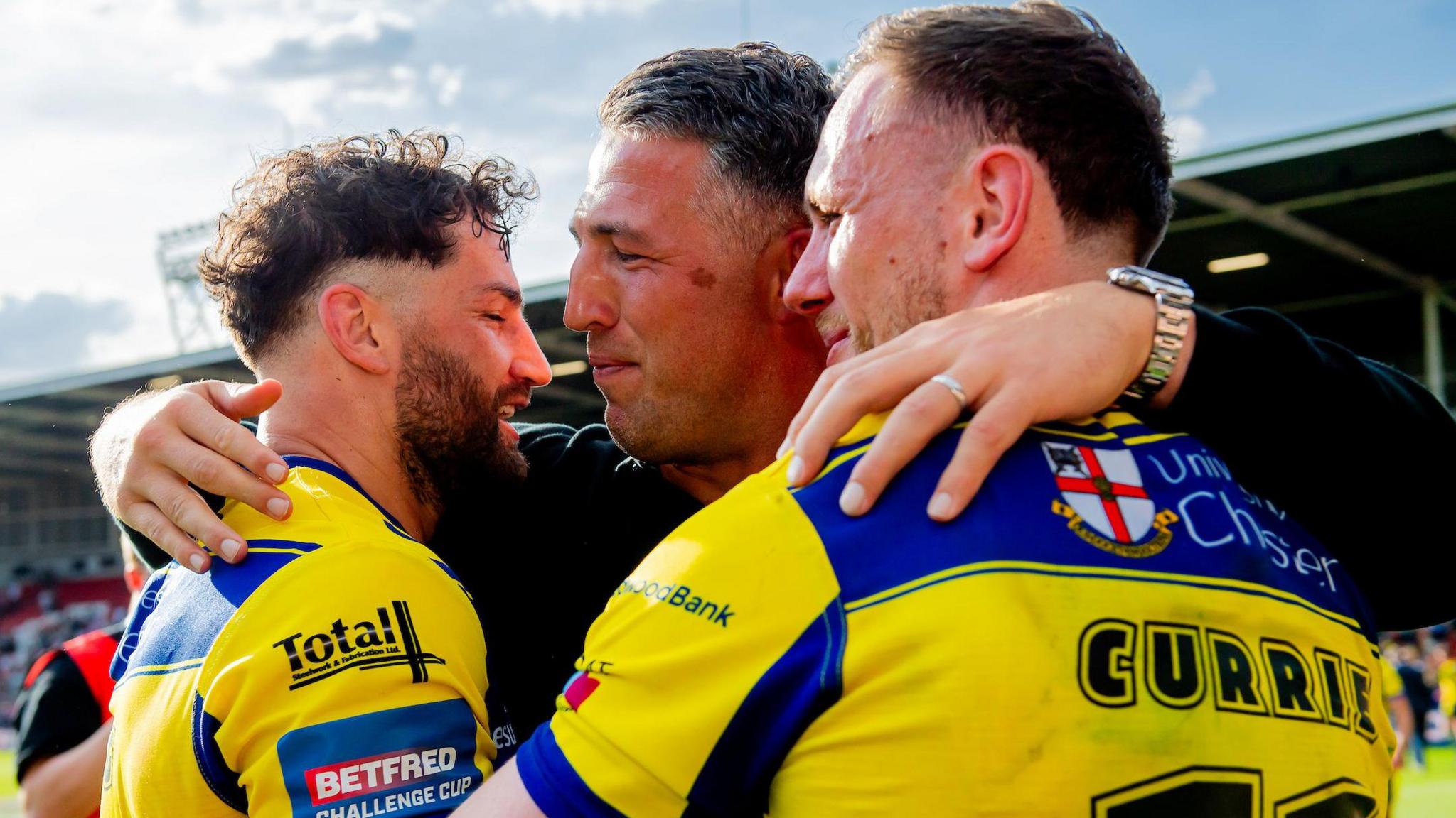 Warrington coach Sam Burgess shares a three-way hug with players Toby King left and Ben Currie right after the Challenge Cup semi-final win over Leigh