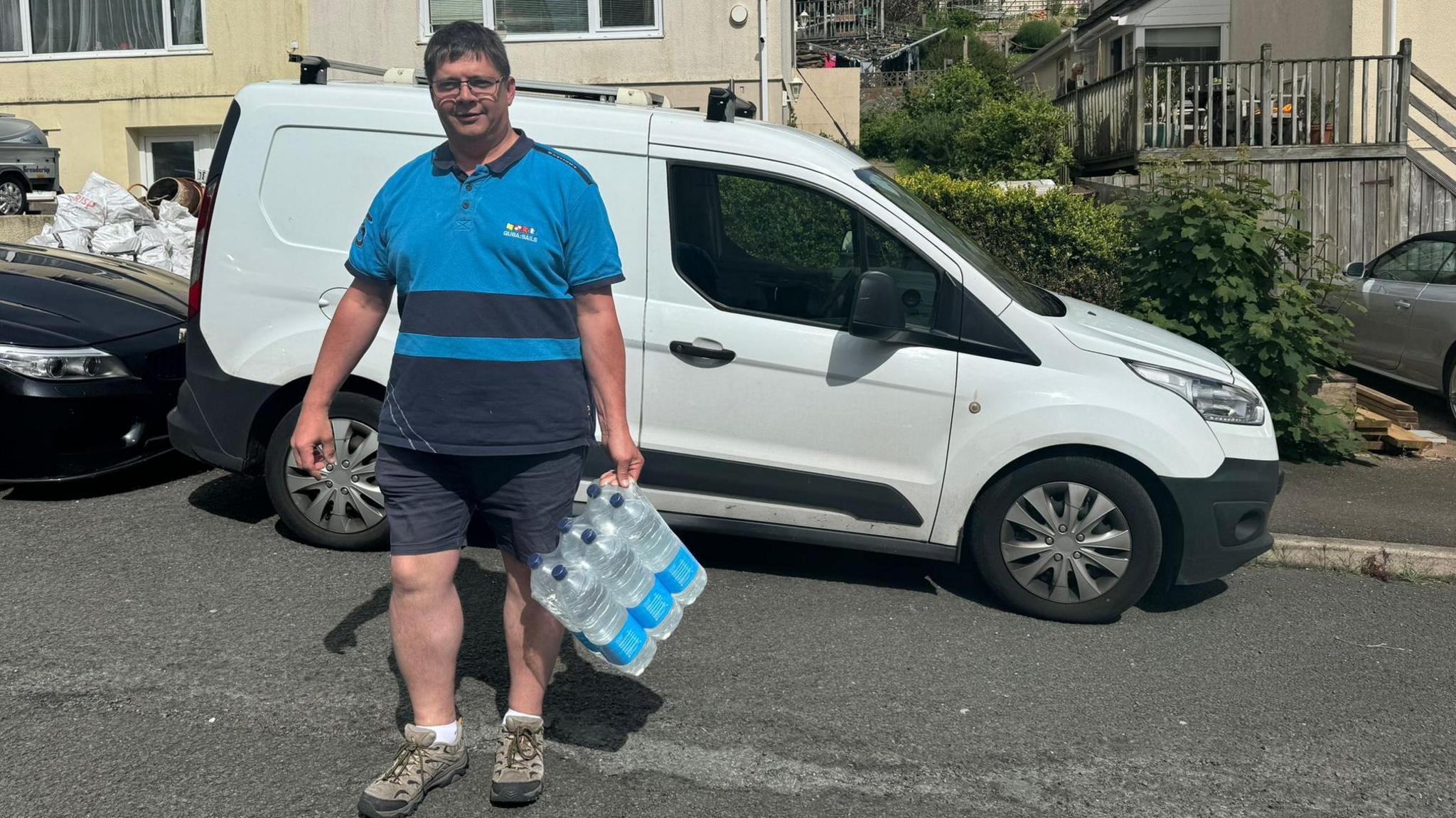 Councillor Andrew Strang delivering water