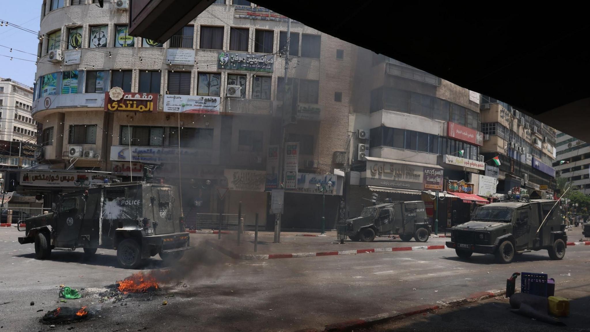 Military vehicles move in the street during an Israeli army operation in the West Bank city of Nablus