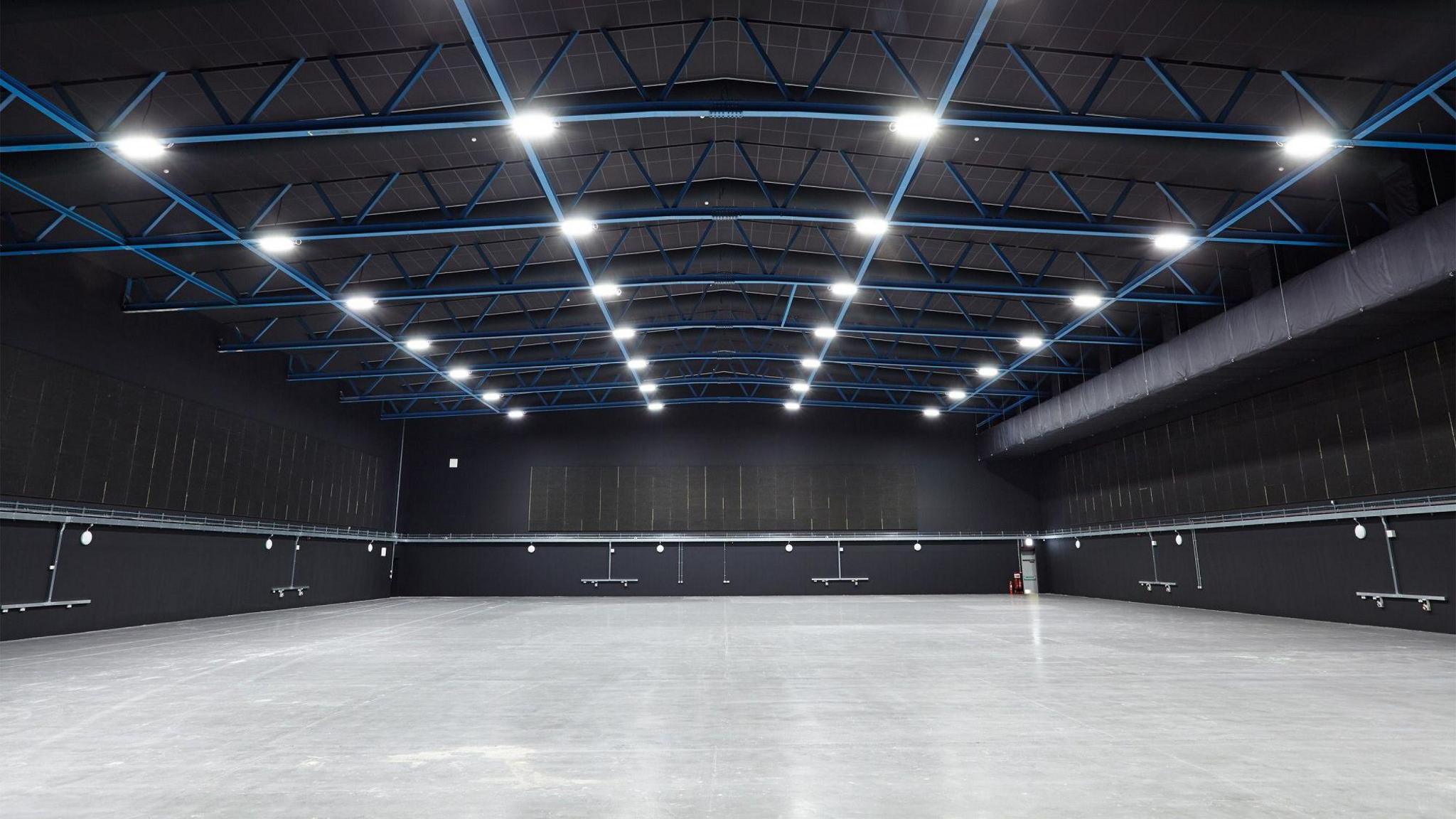 Inside of The Bottle Yard Studio's main studio - a large empty warehouse-style room with black walls and ceiling