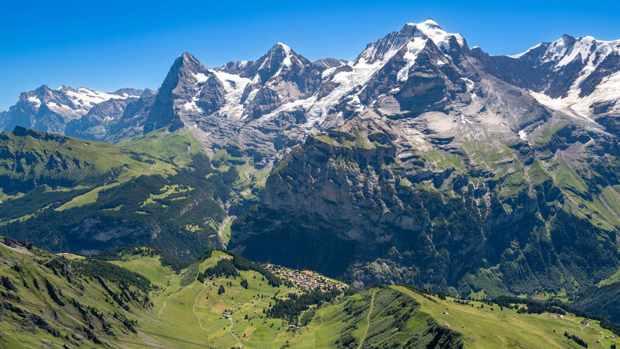 Aerial views of the Jungfrau region of the Swiss Alps.
The village of Murren can be seen in the distance with, Eiger, Monch, and Jungfrau behind it