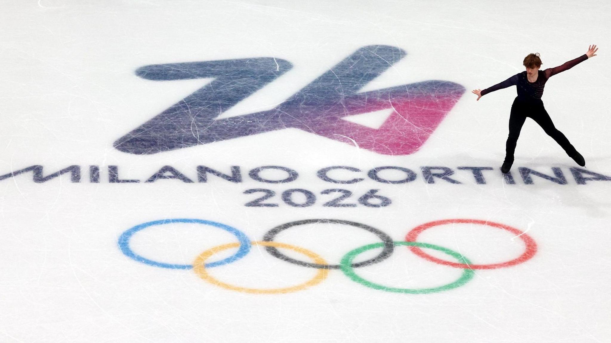 Ed Appleby skates across the Winter Olympics 2026 insignia on the ice at the Forum di Milano