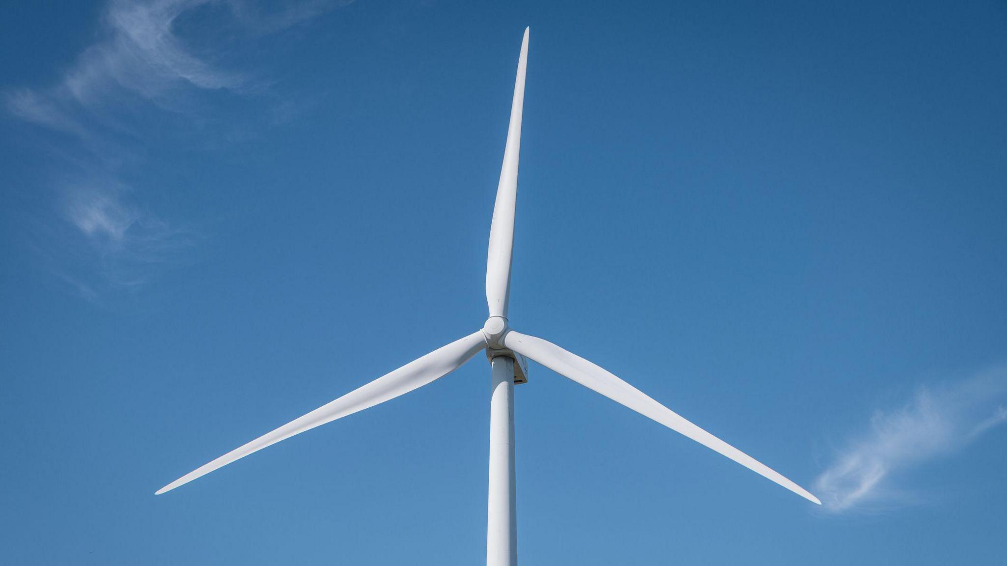 a wind turbine against a blue sky