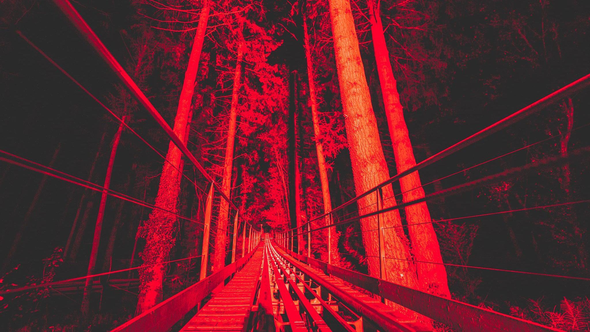 Shot of an abandoned train track at the site, lit up in spooky red lights