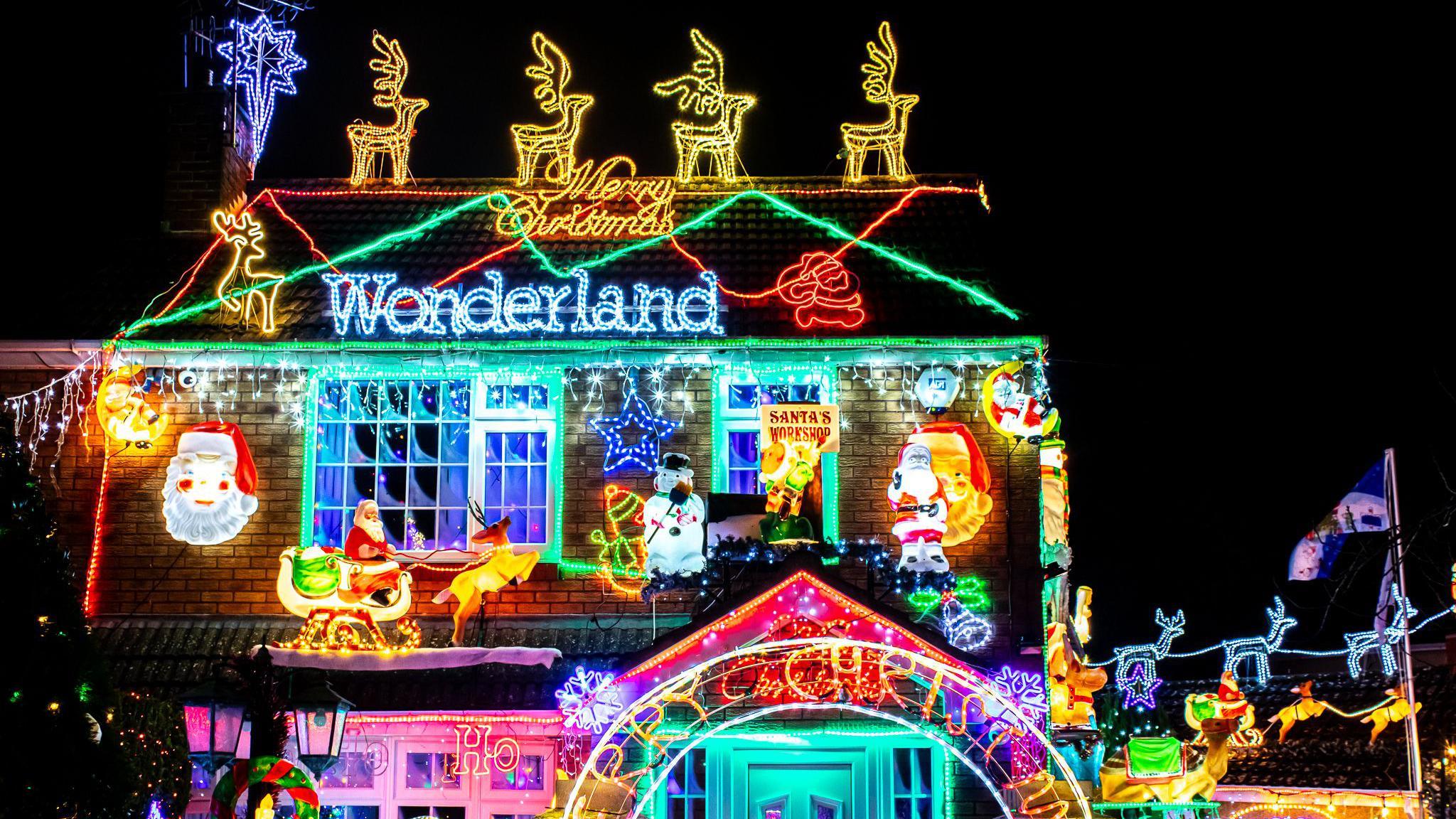 A house covered in illuminated Christmas decorations, including multiple reindeer, snowmen, Father Christmases and strings of multicoloured lights. It is the Brailsford House in Bristol which raises money for the Grand Appeal