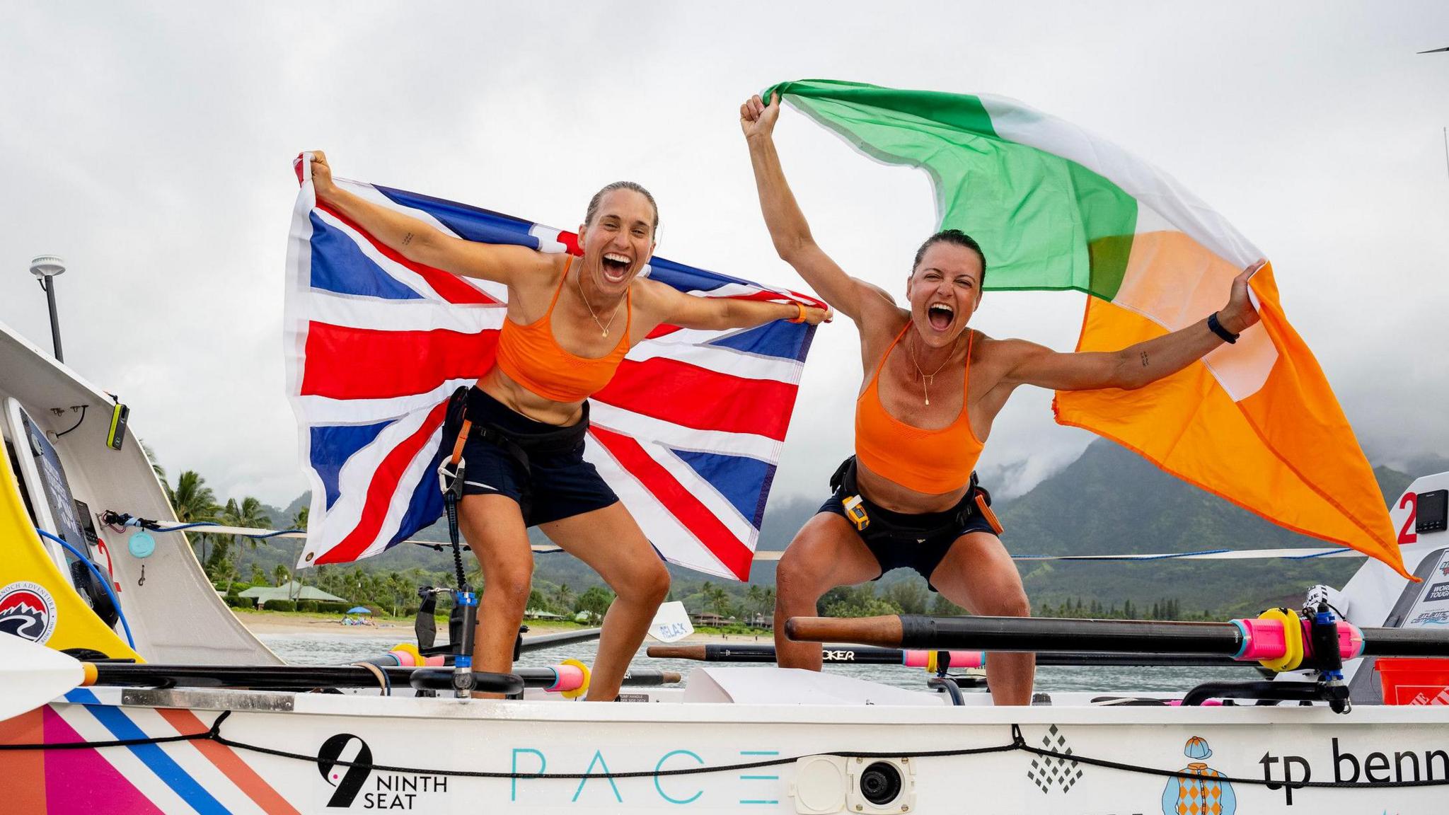 Charlotte Harris and Jessica Oliver waving the UK and Irish flags