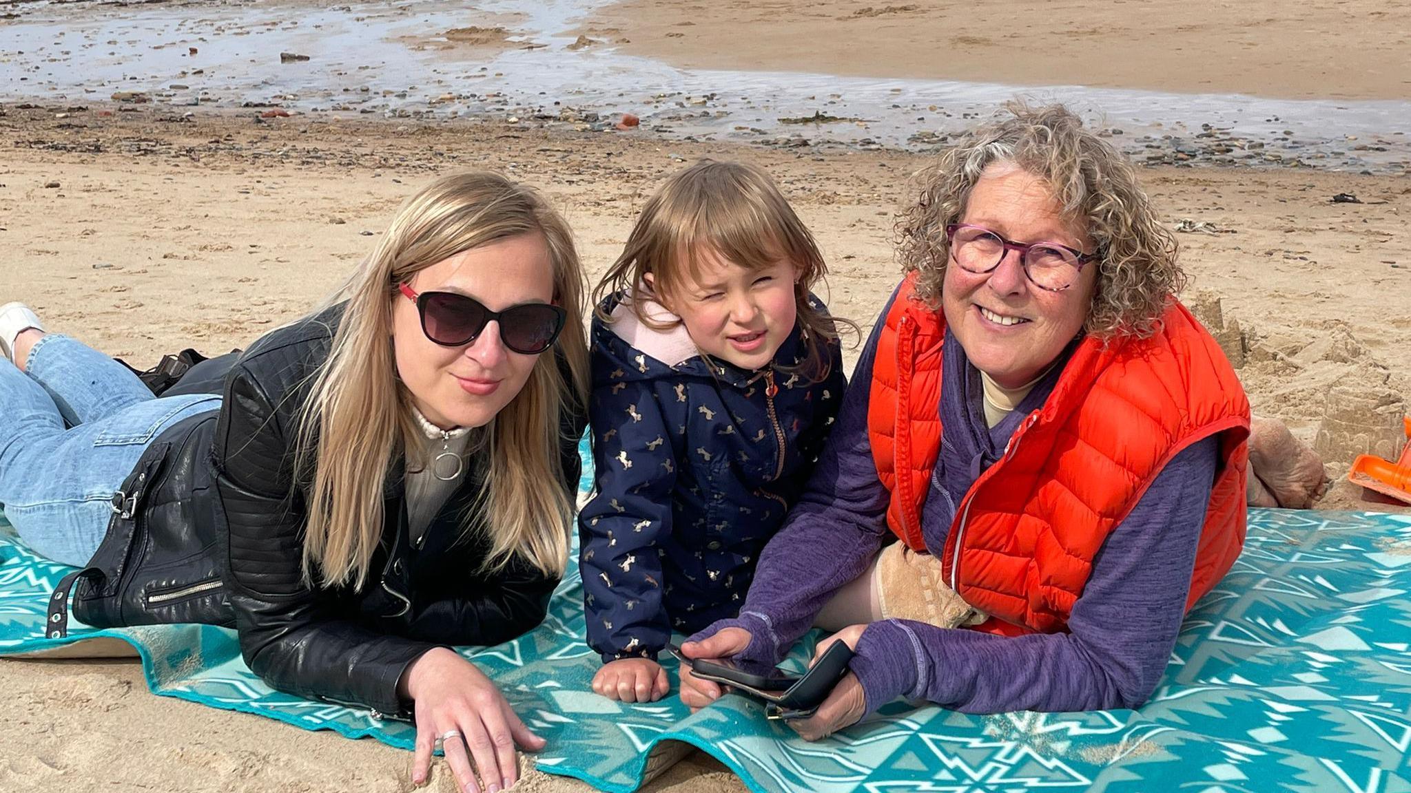 Ms Sievodnieva and her daughter on a beach with her sponsor