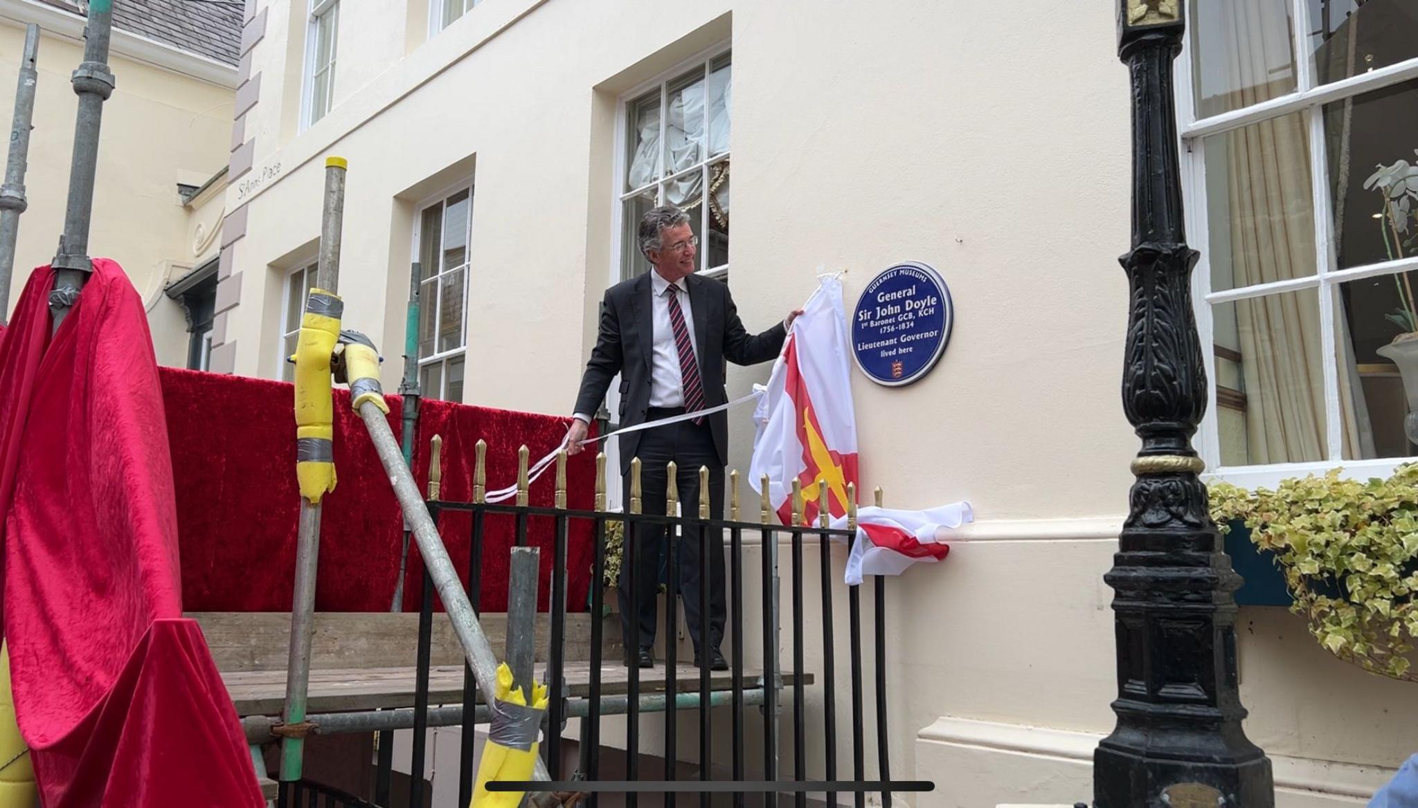 Man unveiling plaque