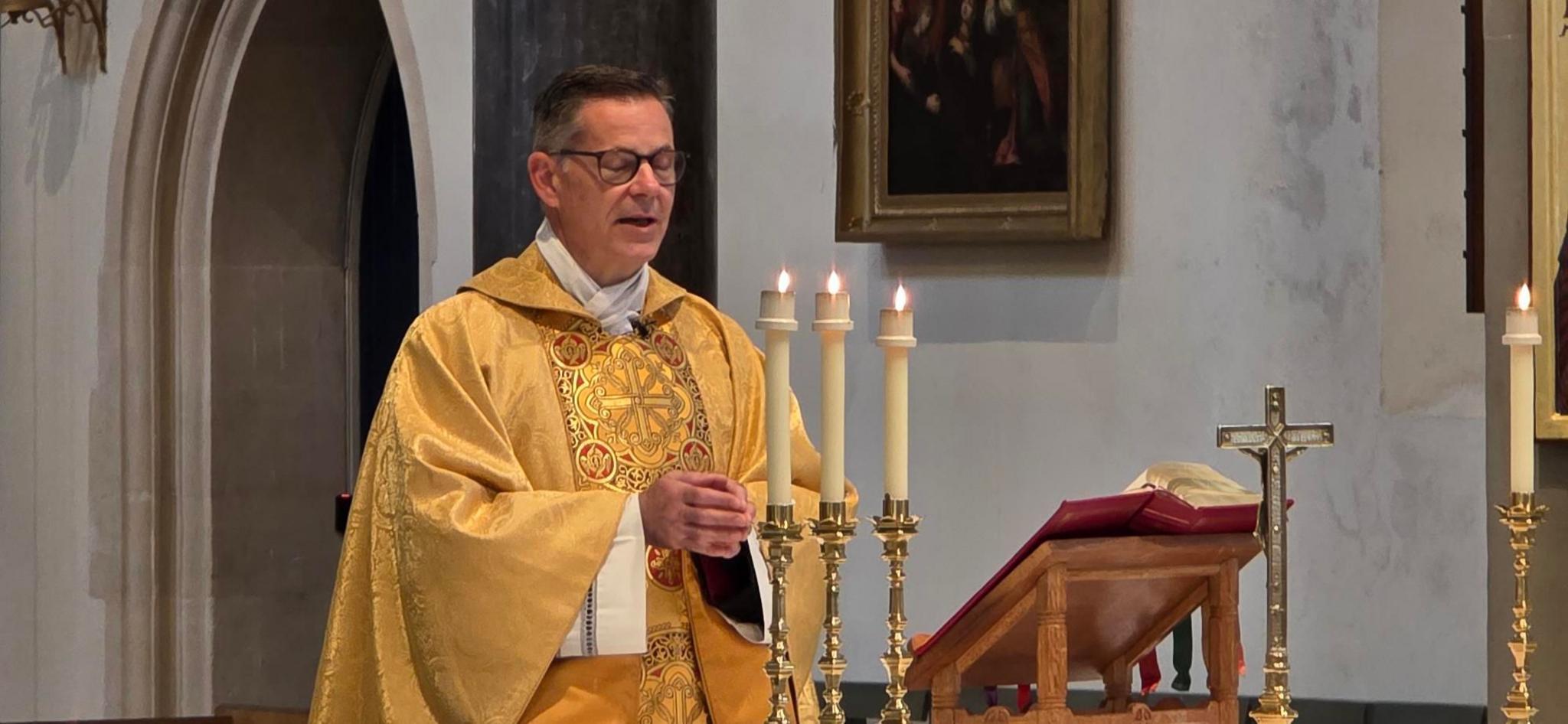 Canon Mark O'Keefe, who has brown hair and wears glasses.