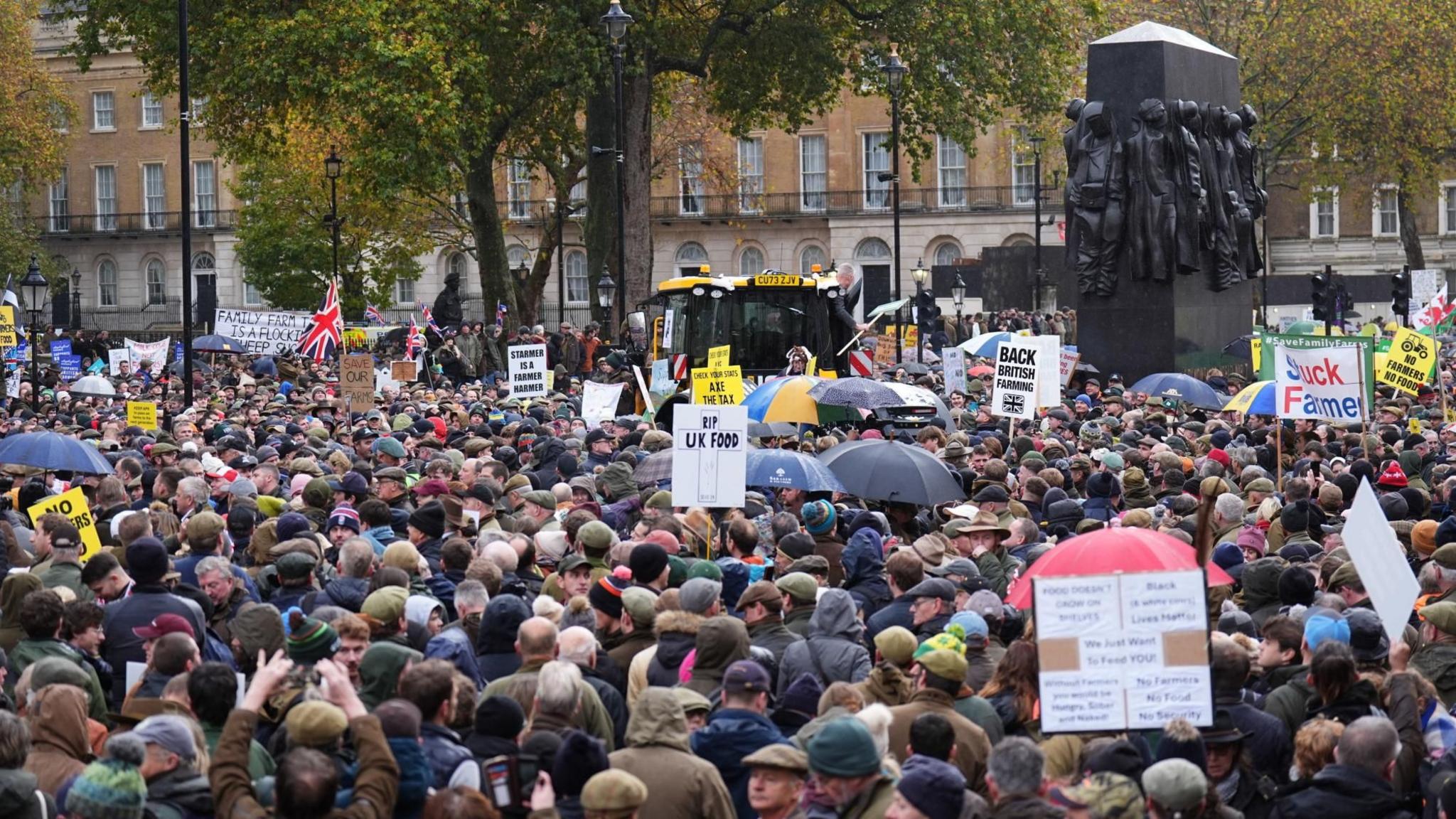 Farmers standing in protest in Westminster, central London - many are holding signs