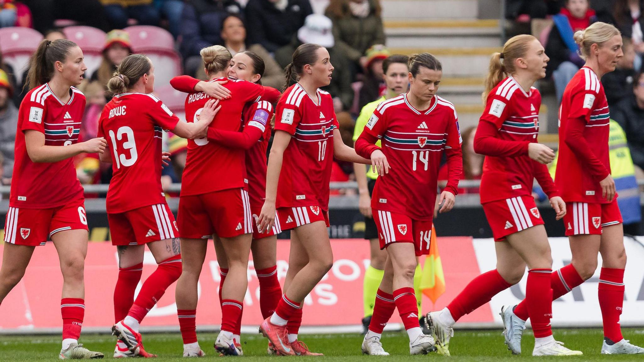 Wales players celebrate a Hannah Cain goal 